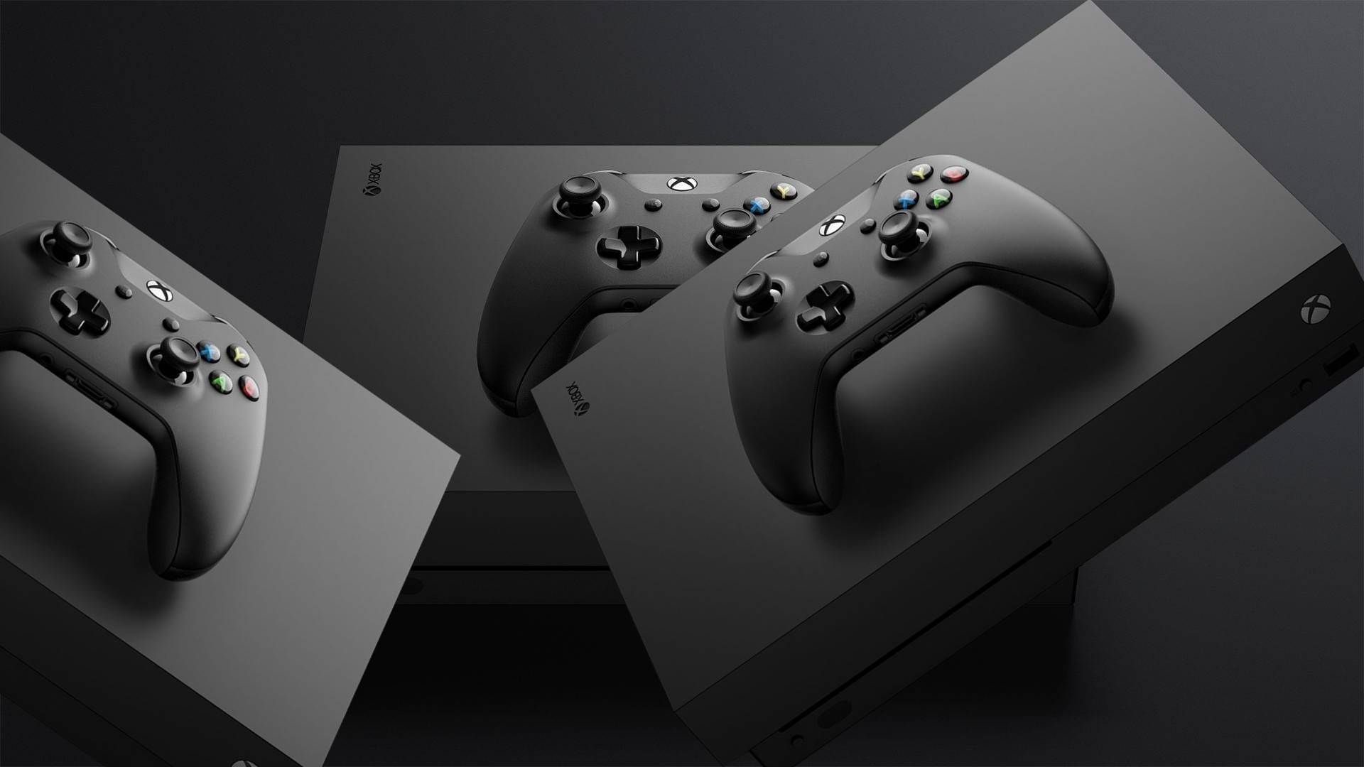 Xbox One X 桌布 壁紙 — 三個時尚的黑色Xbox控制器放在匹配的主機盒上，在簡約的攝影棚拍攝中。