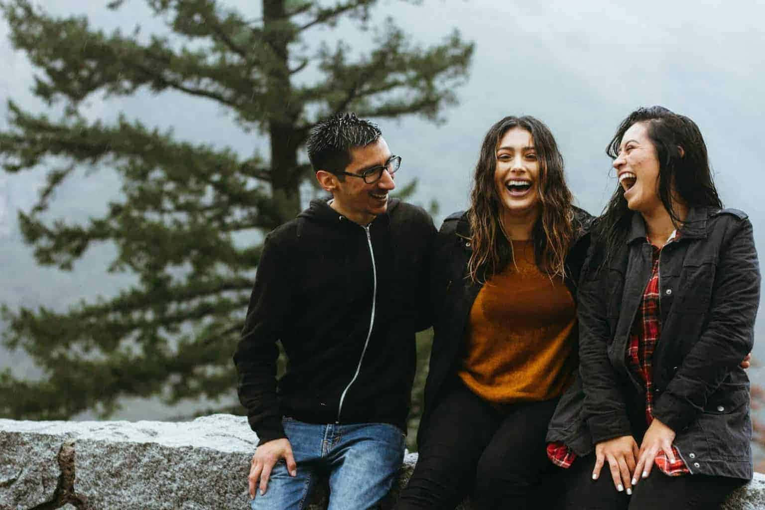Laughing 桌布 壁紙 — 三個朋友在松樹旁霧氣瀰漫的山崖上一起大笑。
