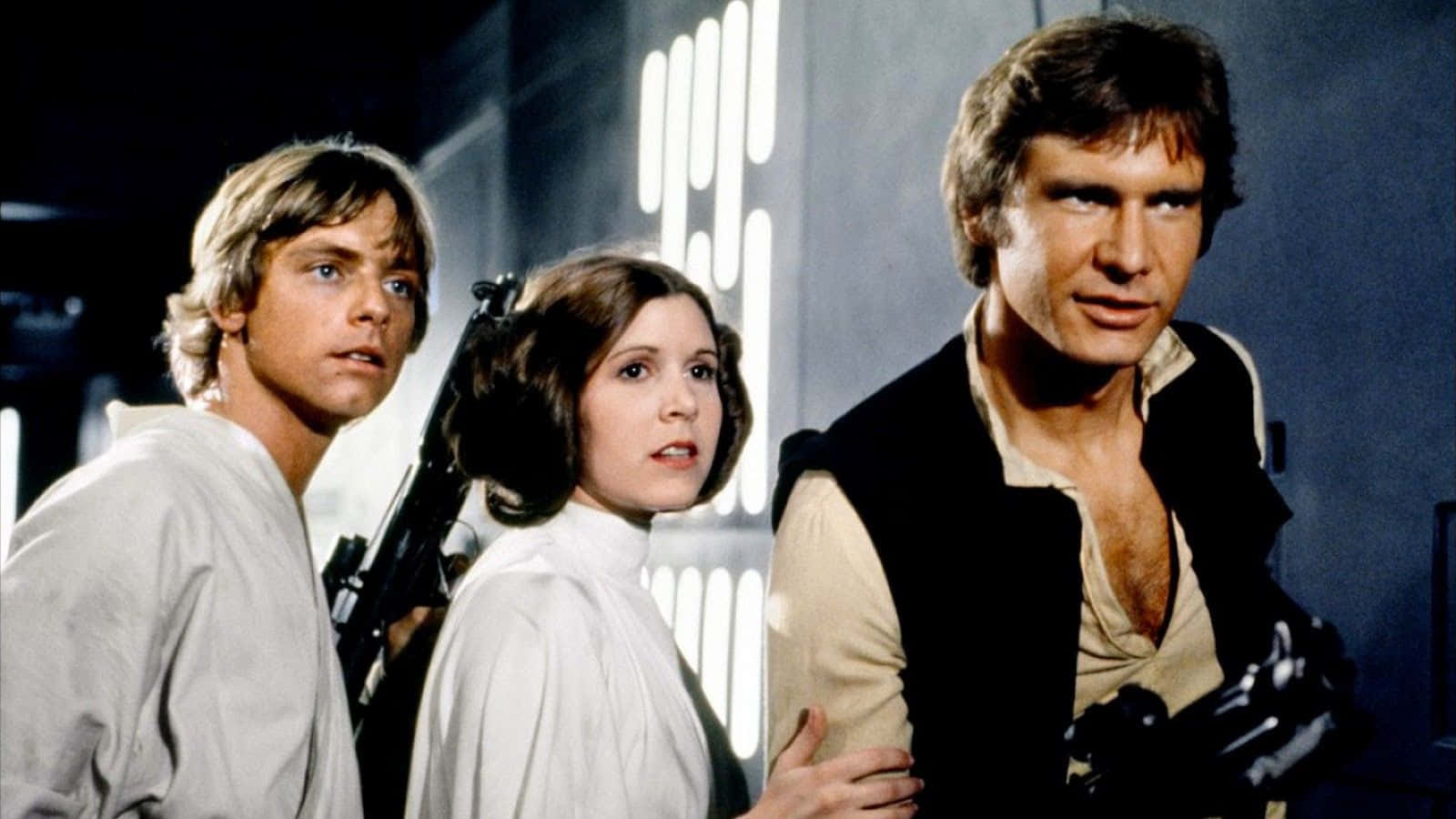 A New Hope 桌布 壁紙 — 三個標誌性的星際大戰角色在光線昏暗的太空船走廊中保持警覺，身後有發光的垂直燈光。