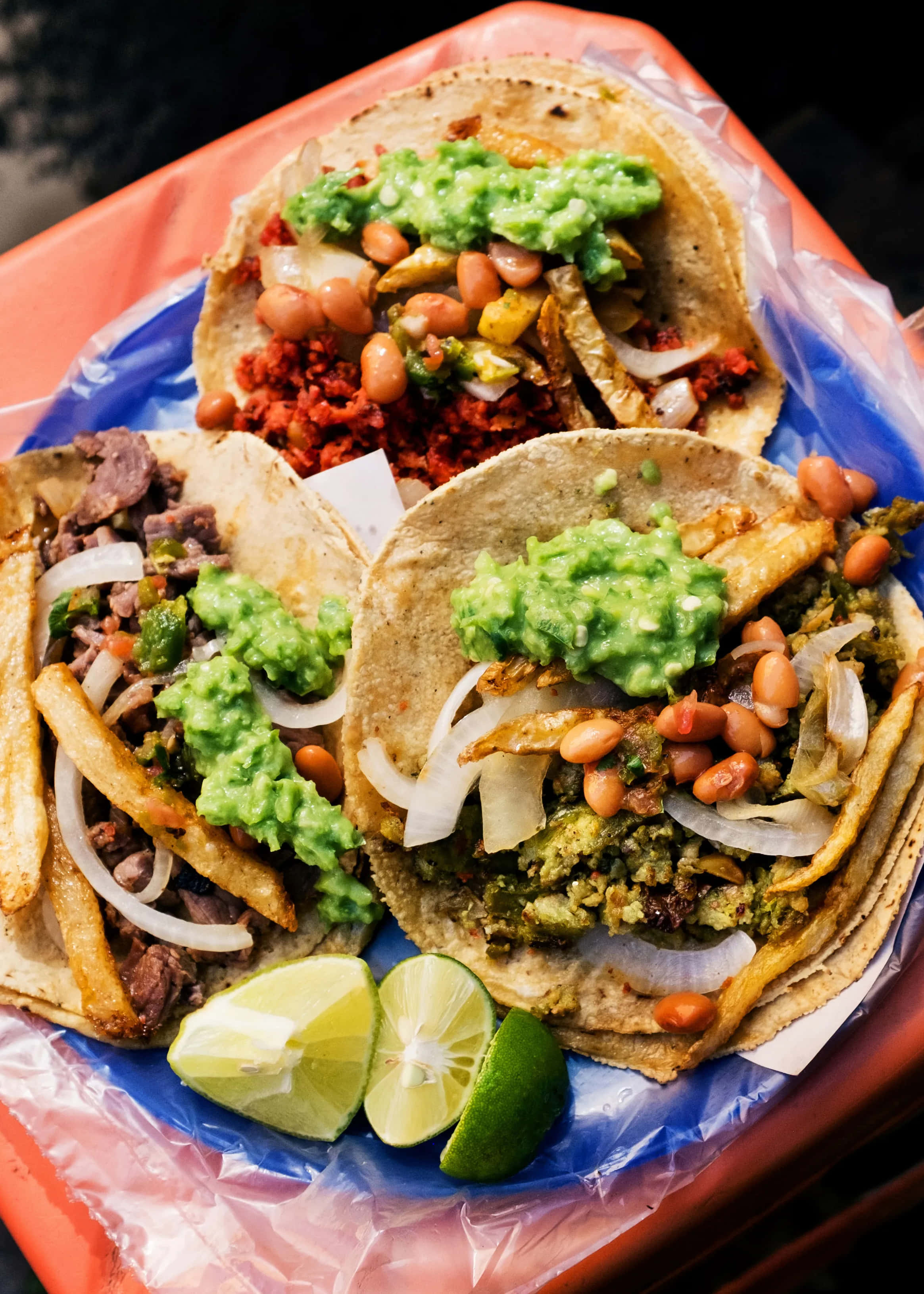 Mexico Foods 桌布 壁紙 — 三個滿載的墨西哥捲餅，配上酪梨豆、洋蔥和薯條，放在紅色托盤上，伴以萊姆角。
