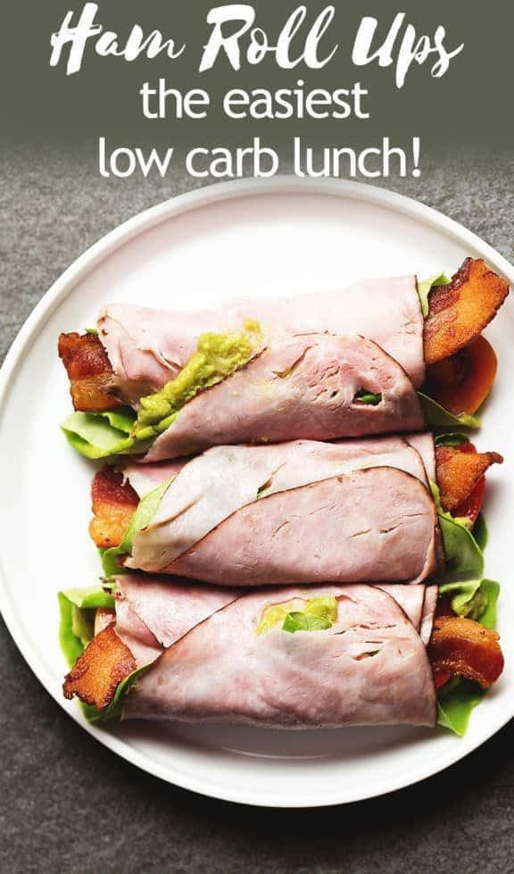 Black Forest Ham 桌布 壁紙 — 三個火腿卷，內有酪梨、培根和生菜，整齊地擺放在白色盤子上。