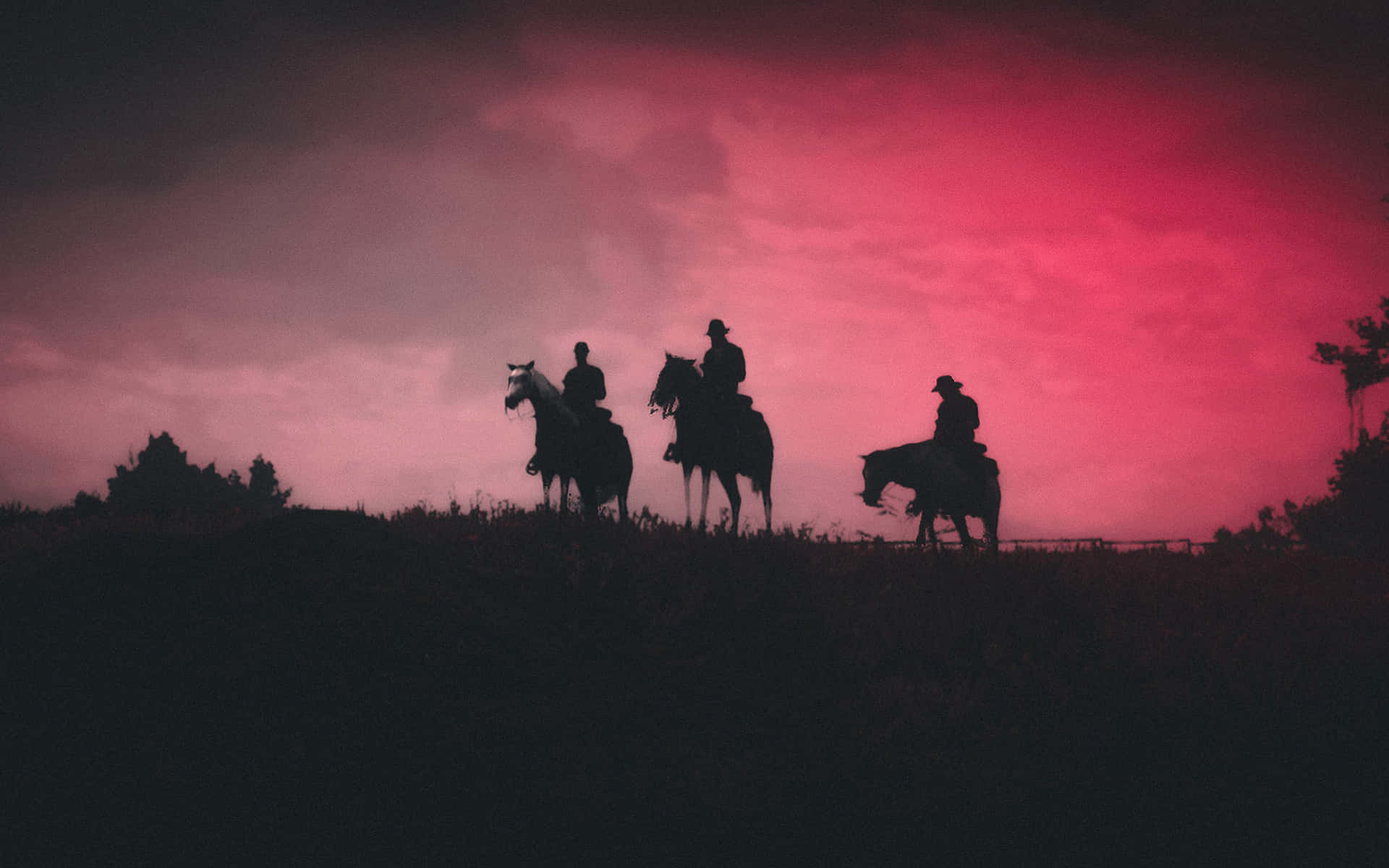 Cowboy 桌布 壁紙 — 三個牛仔剪影騎馬越過山丘，背景是戲劇性的粉紅和紫色日落天空。