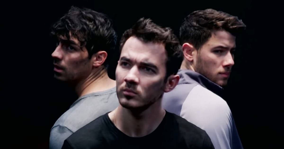 Jonas Brothers 桌布 壁紙 — 三個男人側面輪廓，背景為黑色，戲劇性燈光突出他們嚴肅的表情。