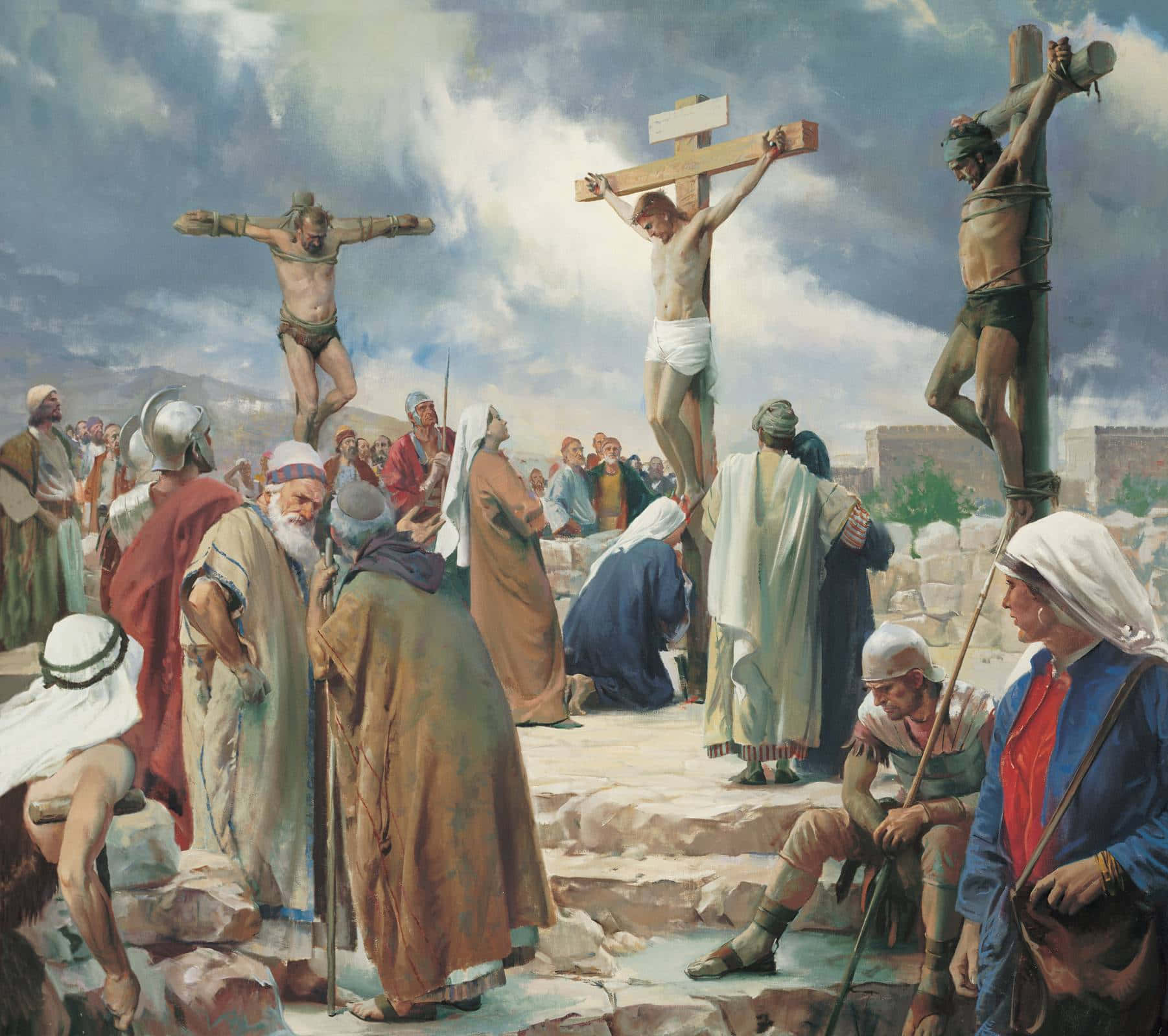Jesus Crucifixion 桌布 壁紙 — 三個男人在戲劇性的多雲天空下被釘十字架，下方聚集著穿著古裝長袍的旁觀者。
