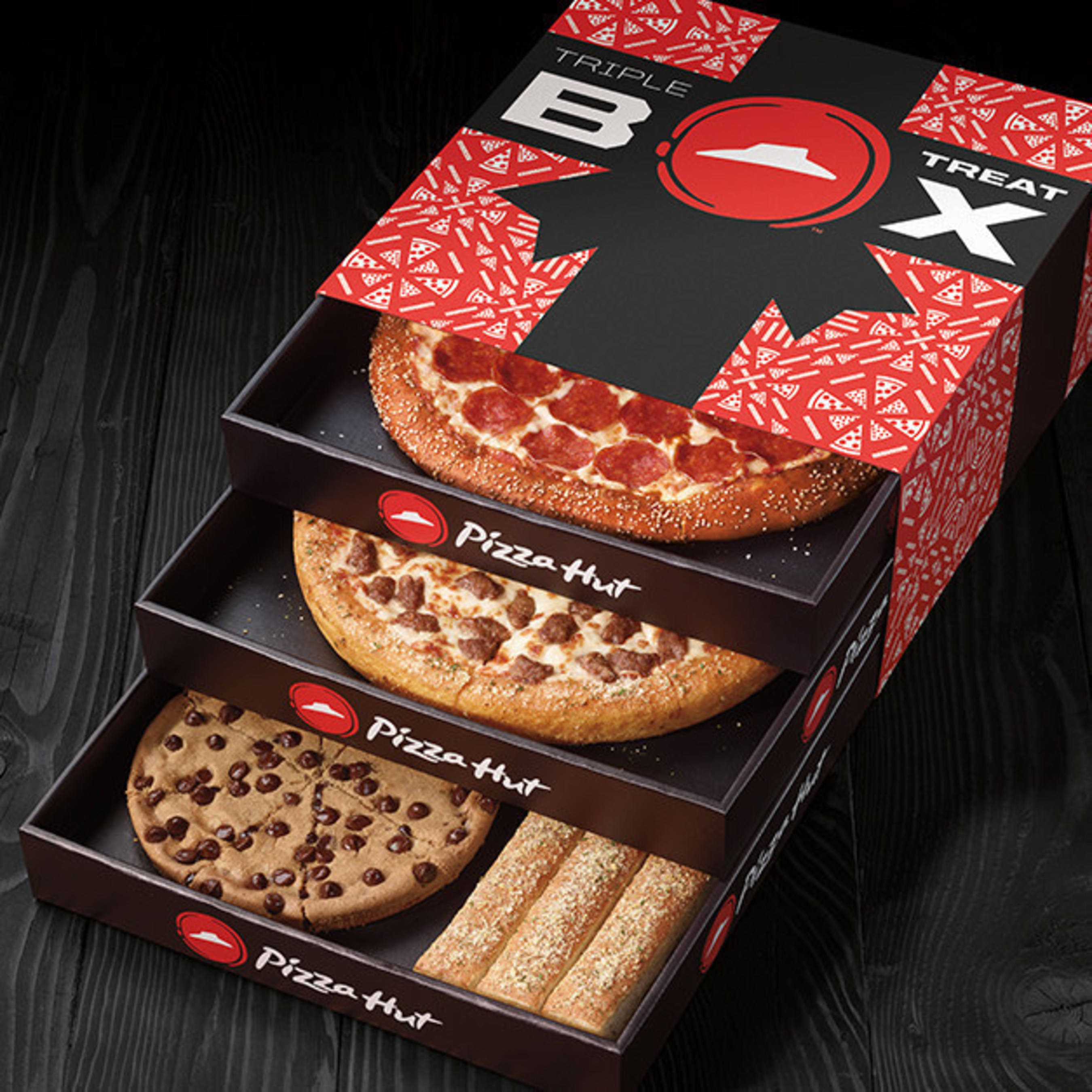 Hut 桌布 壁紙 — 三個疊起的Pizza Hut盒展示出義大利辣香腸香腸和巧克力曲奇披薩，配以麵包棒，放在深色木面上。