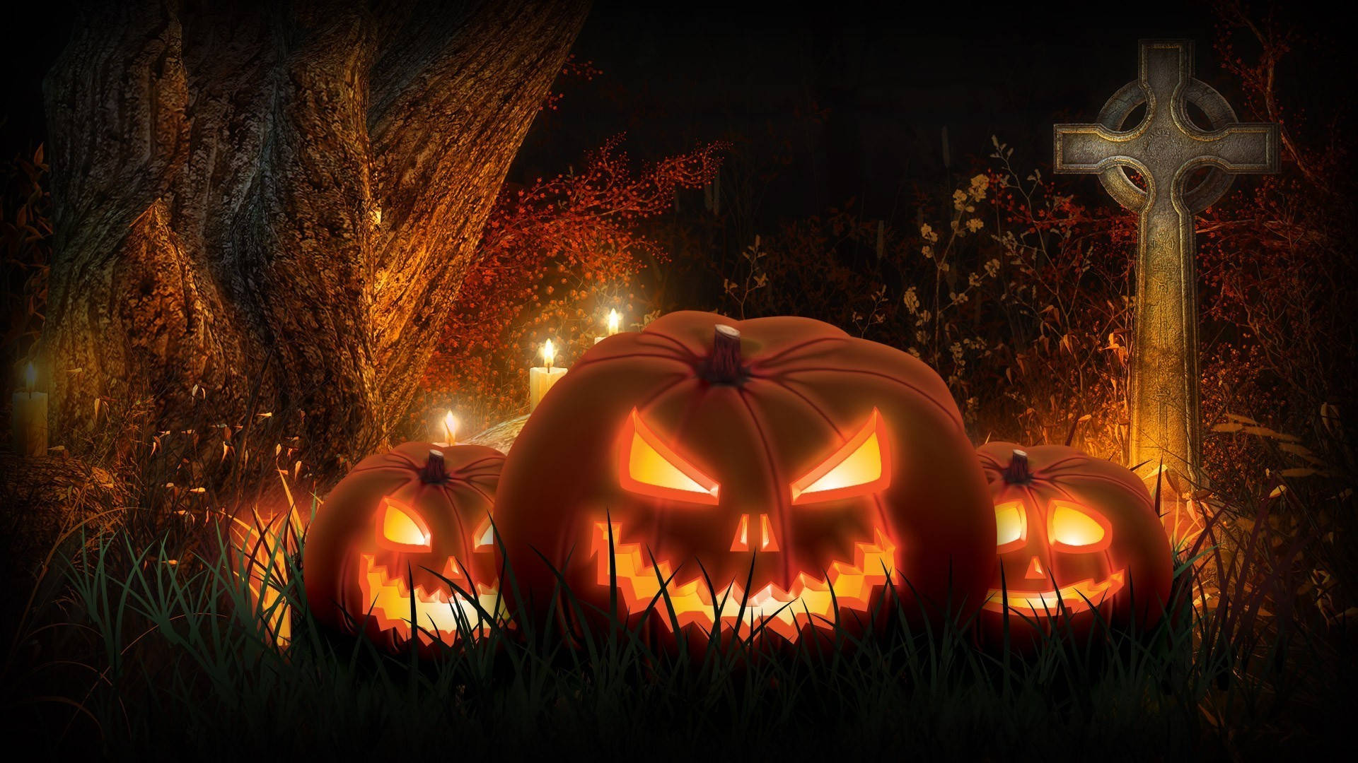 Halloween Pumpkin 桌布 壁紙 — 三個發光的傑克南瓜燈，帶有鋒利的牙齒，坐在草地上，旁邊是一個風化的凱爾特十字架，在黑暗的夜空下。