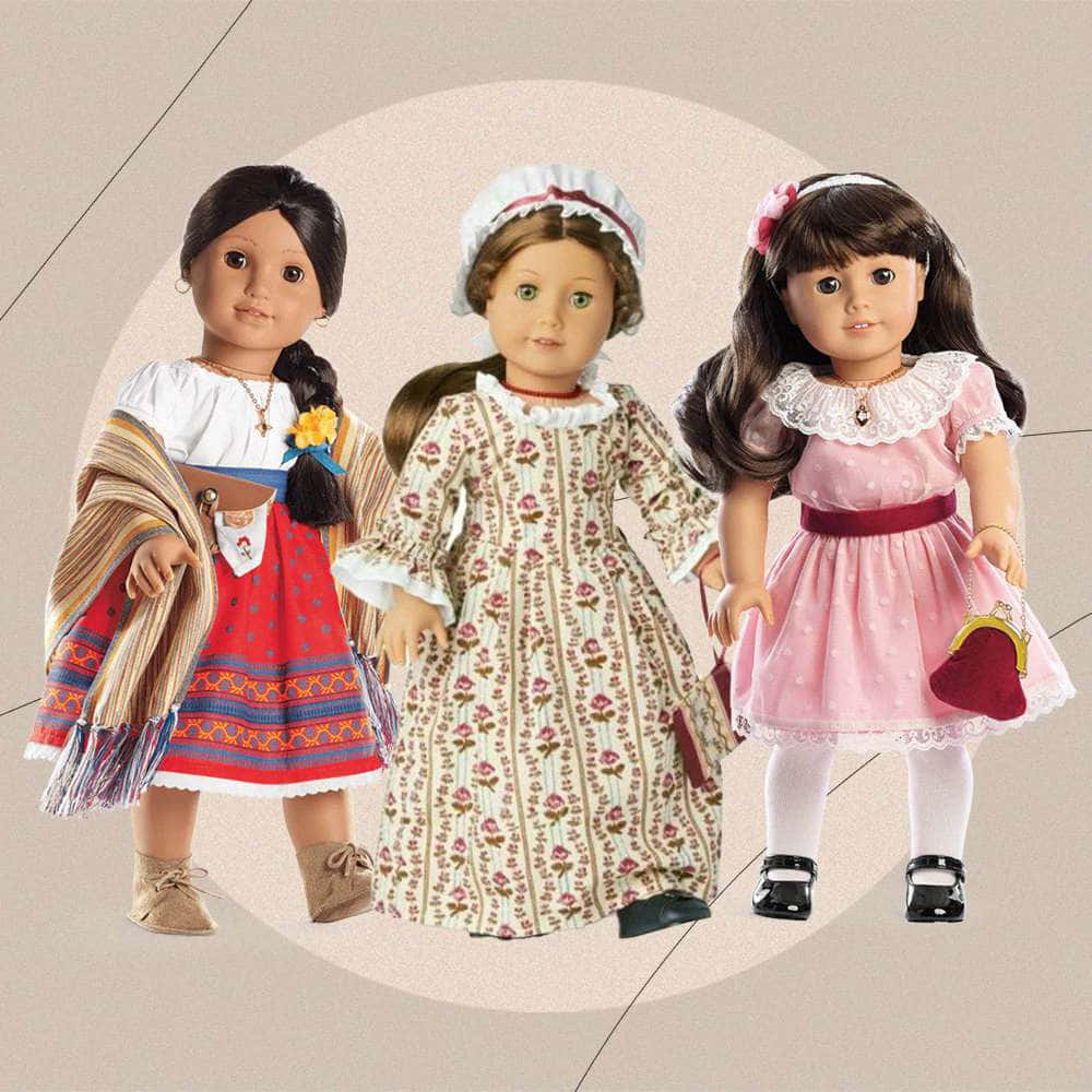 american girl 桌布 壁紙 — 三個穿著不同文化服飾的美國女孩娃娃，站在柔和的米色圓形背景前。
