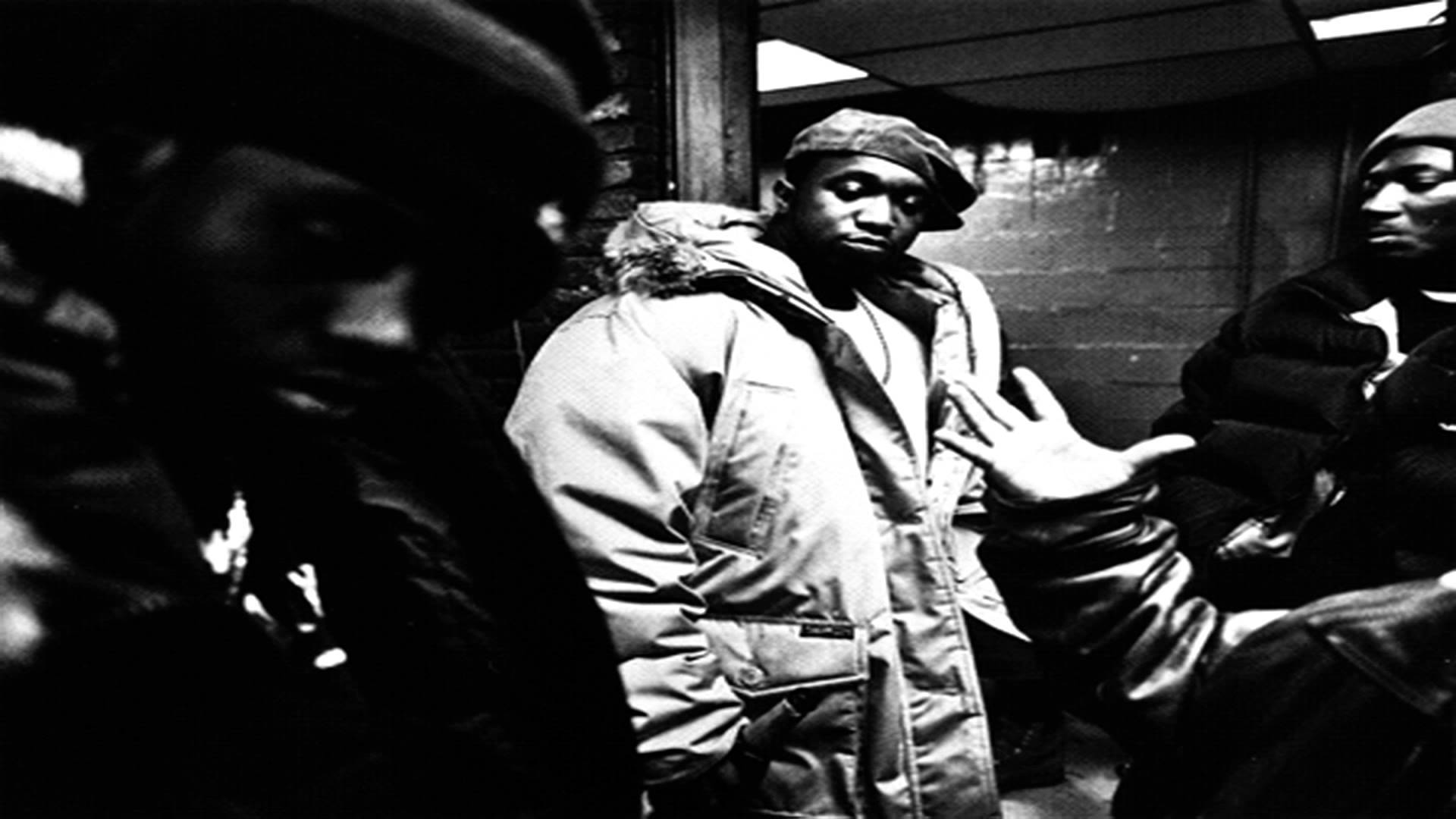 Hip Hop 桌布 壁紙 — 三個穿著厚重冬季外套的男人站在昏暗的城市小巷中，其中一個做著手勢，其他人則帶著嚴肅的表情看著。