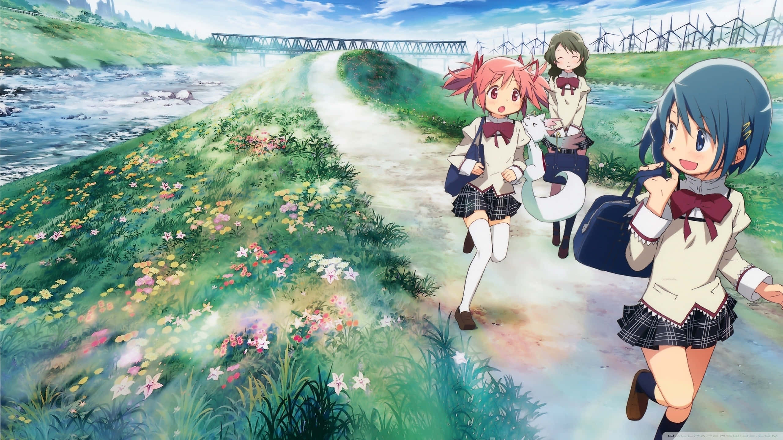 puella magi madoka magica 桌布 壁紙 — 三個穿著校服的動漫女孩在明亮的藍天下，沿著河邊一條開滿鮮花的小徑歡快地奔跑。