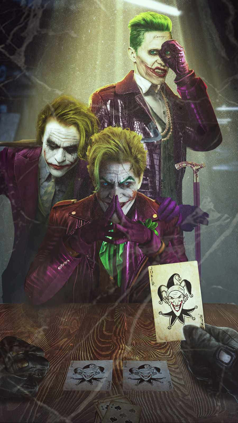 Batman Three Jokers 桌布 壁紙 — 三個穿著紫色西裝的威脅性小丑坐在木桌旁，在戲劇性燈光下玩撲克牌。