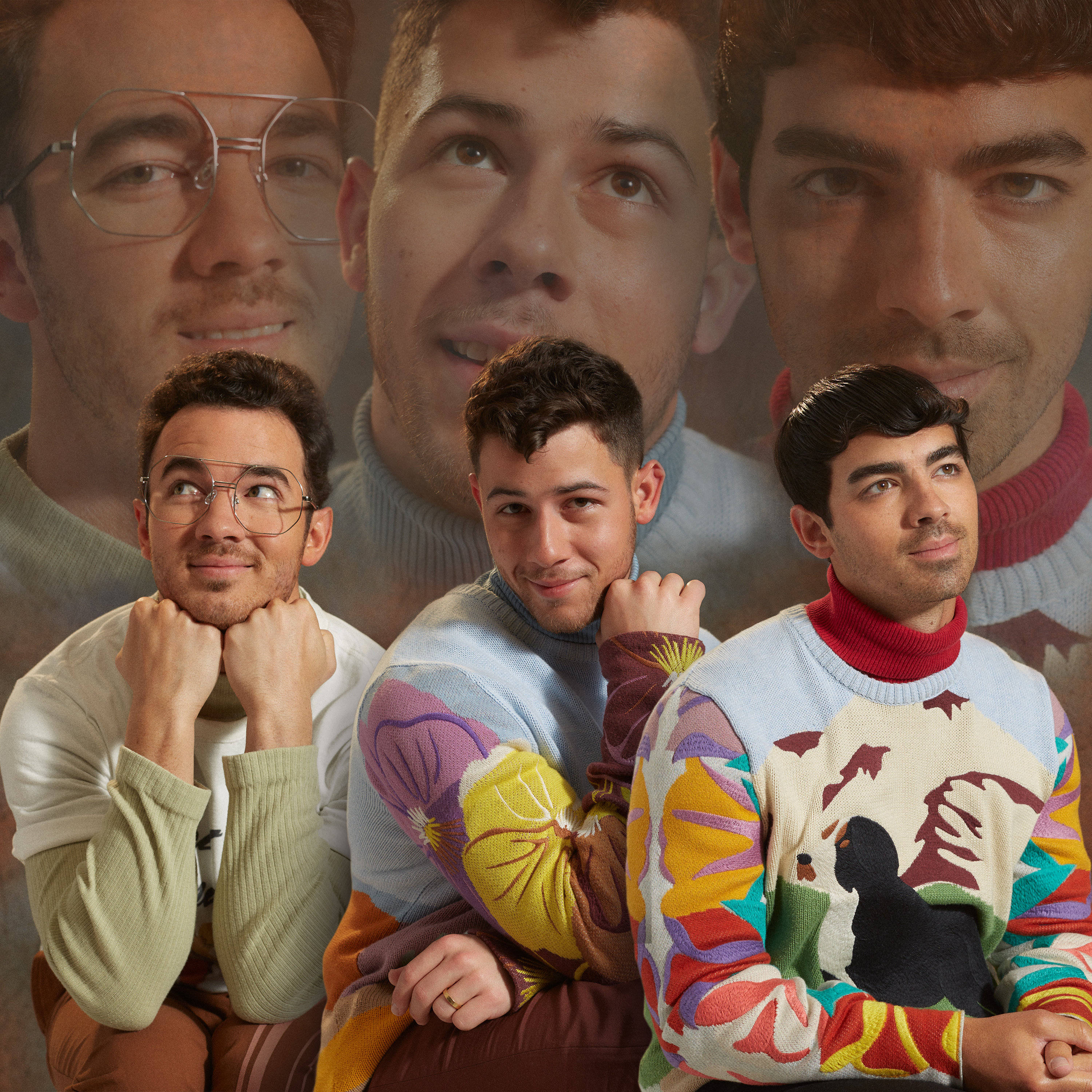 Jonas Brothers 桌布 壁紙 — 三個穿著色彩繽紛毛衣的男人，以自己褪色的臉孔為背景，自信地擺姿勢。