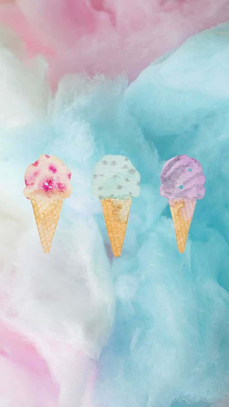 Pastel Watercolor 桌布 壁紙 — 三個粉彩冰淇淋甜筒漂浮在夢幻棉花糖天空上，呈現柔和的粉紅、藍色和白色漩渦。