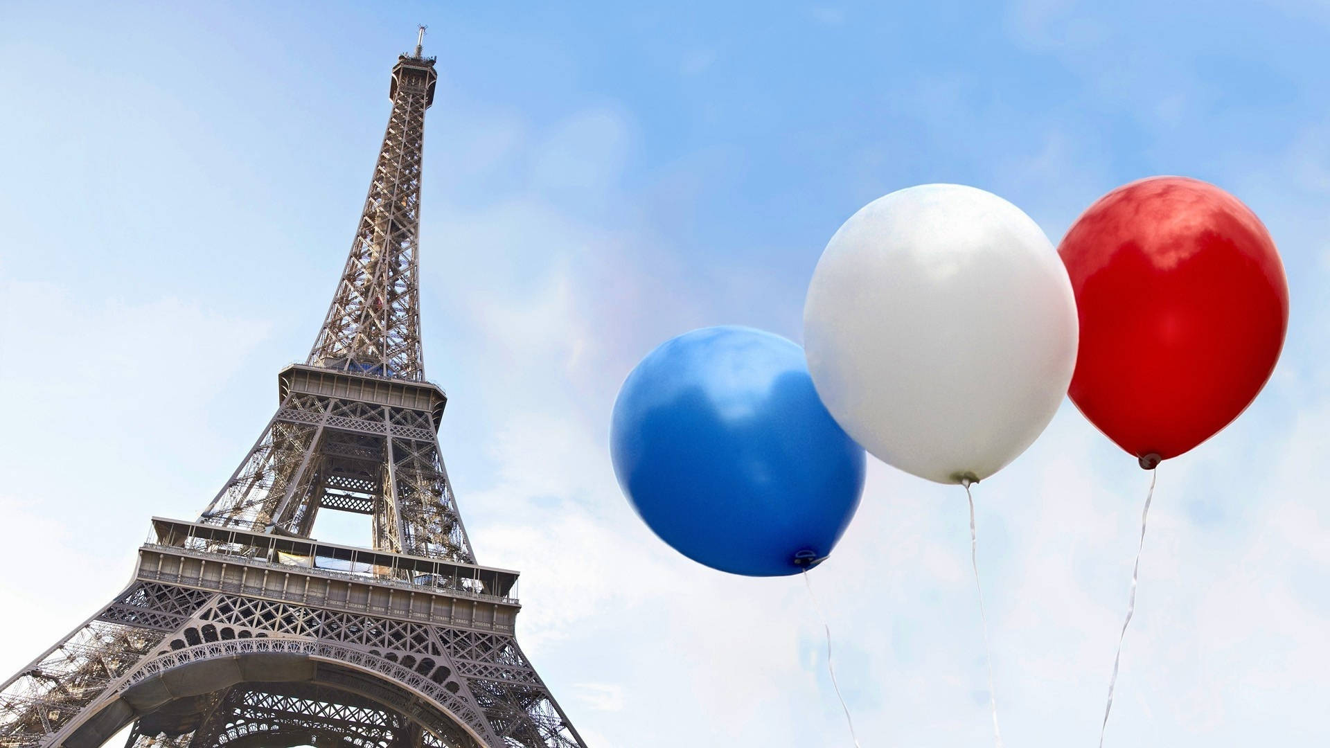 France Flag 桌布 壁紙 — 三個紅、白、藍氣球在巴黎標誌性艾菲爾鐵塔旁的晴朗天空中飄浮。