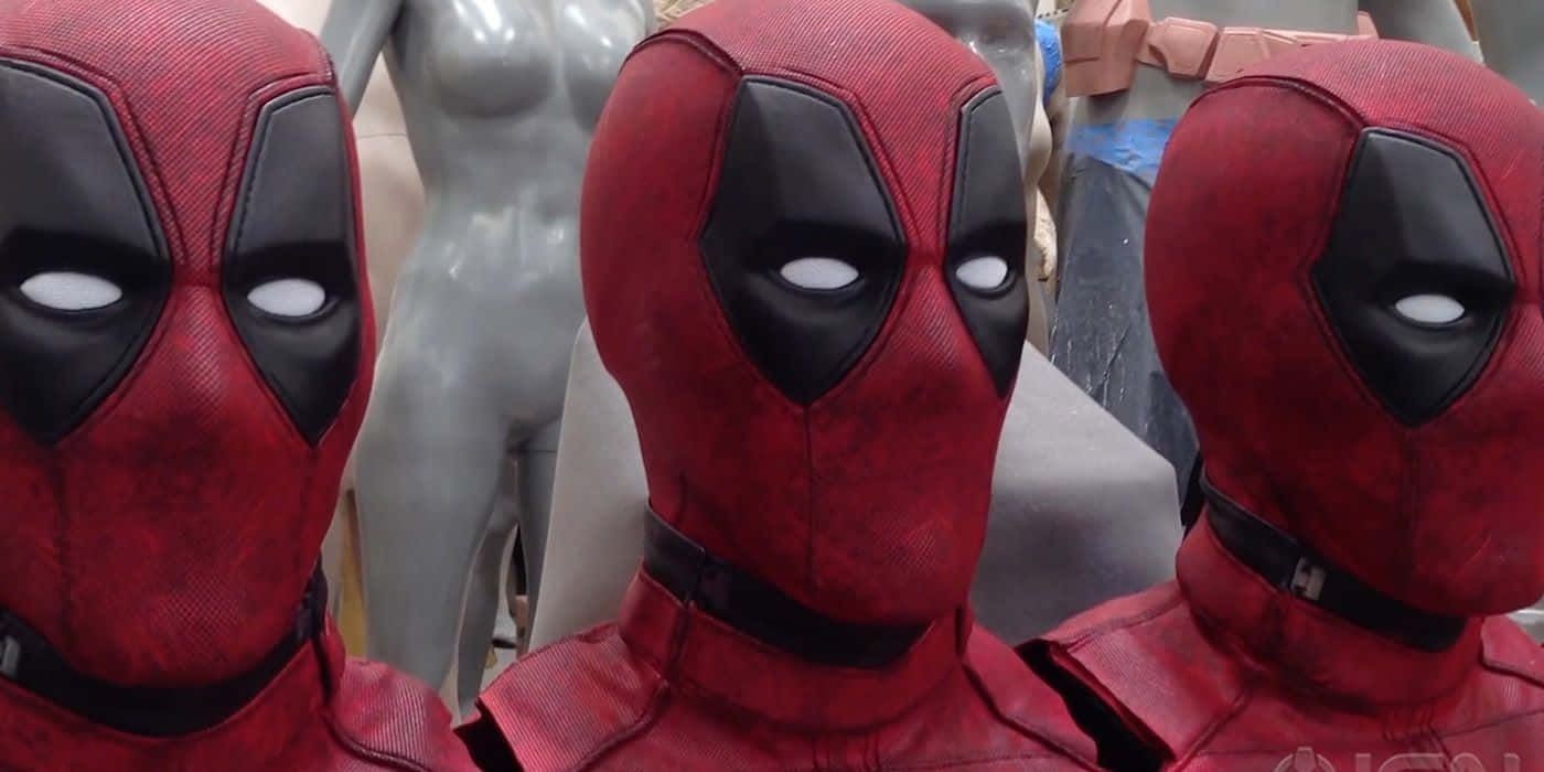 Deadpool Mask 桌布 壁紙 — 三個紅色和黑色的死侍面具並排放在服裝工作室的人體模型上。