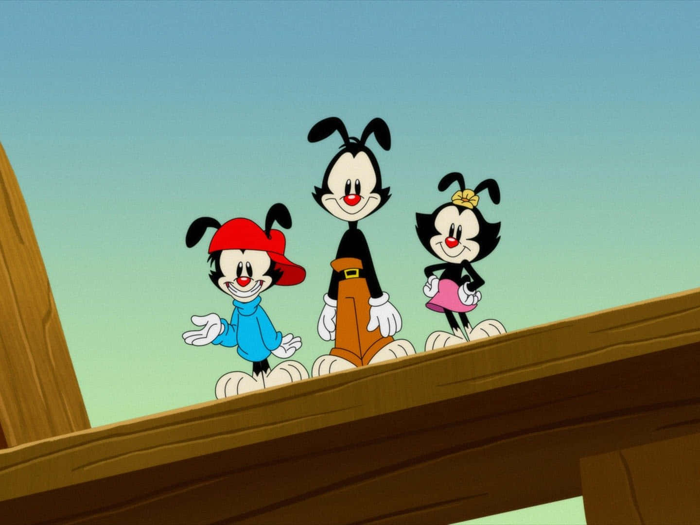 Animaniacs 桌布 壁紙 — 三個經典卡通角色愉快地站在木樑上，背景是晴朗的天空。