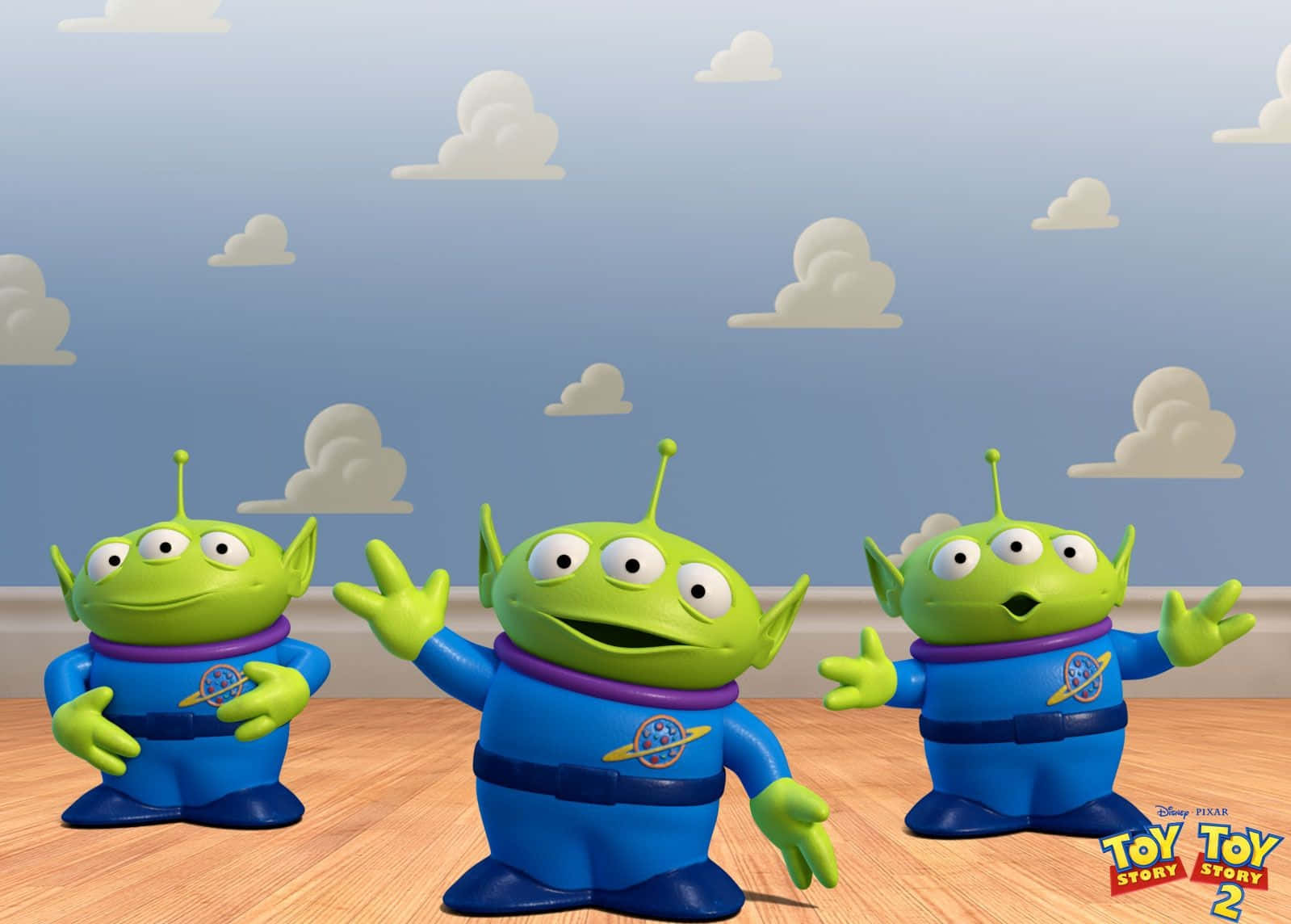 Toy Story Cloud 桌布 壁紙 — 三個綠色三眼外星人穿著藍色太空衣，站在木地板上，天空多雲。
