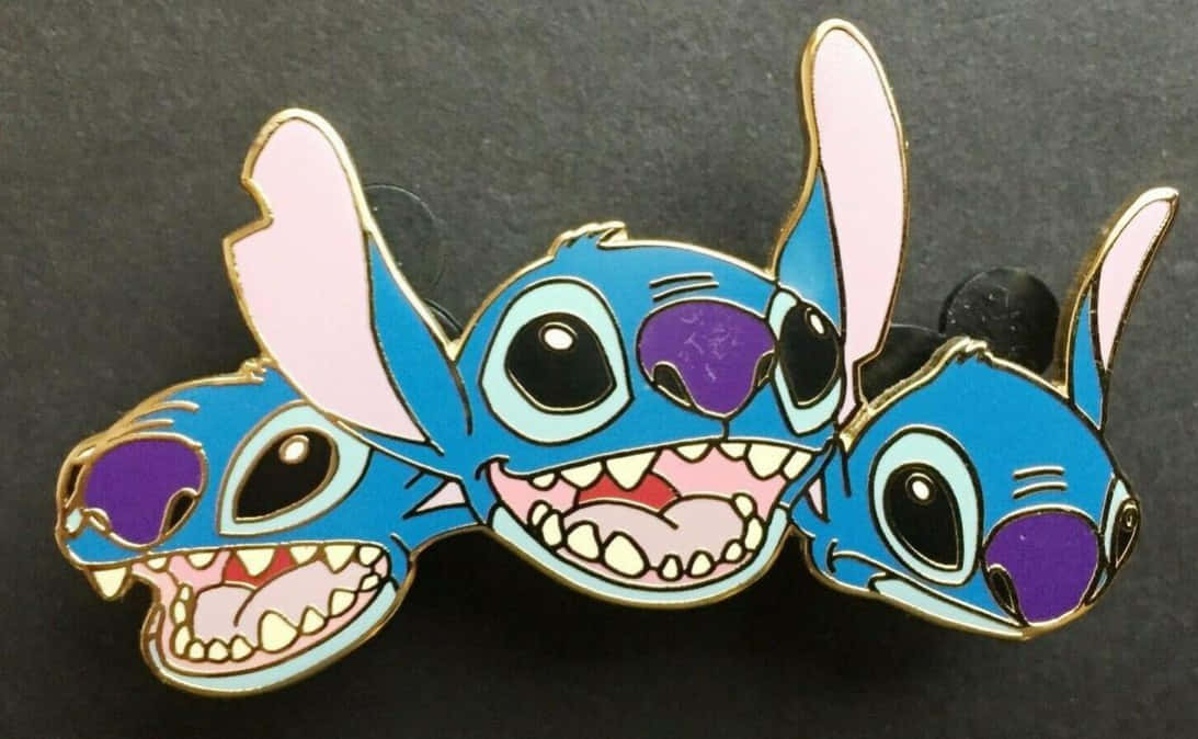 Stitch Profile 桌布 壁紙 — 三個藍色外星人史迪奇的琺瑯別針，以俏皮姿勢展示在深灰色背景上。