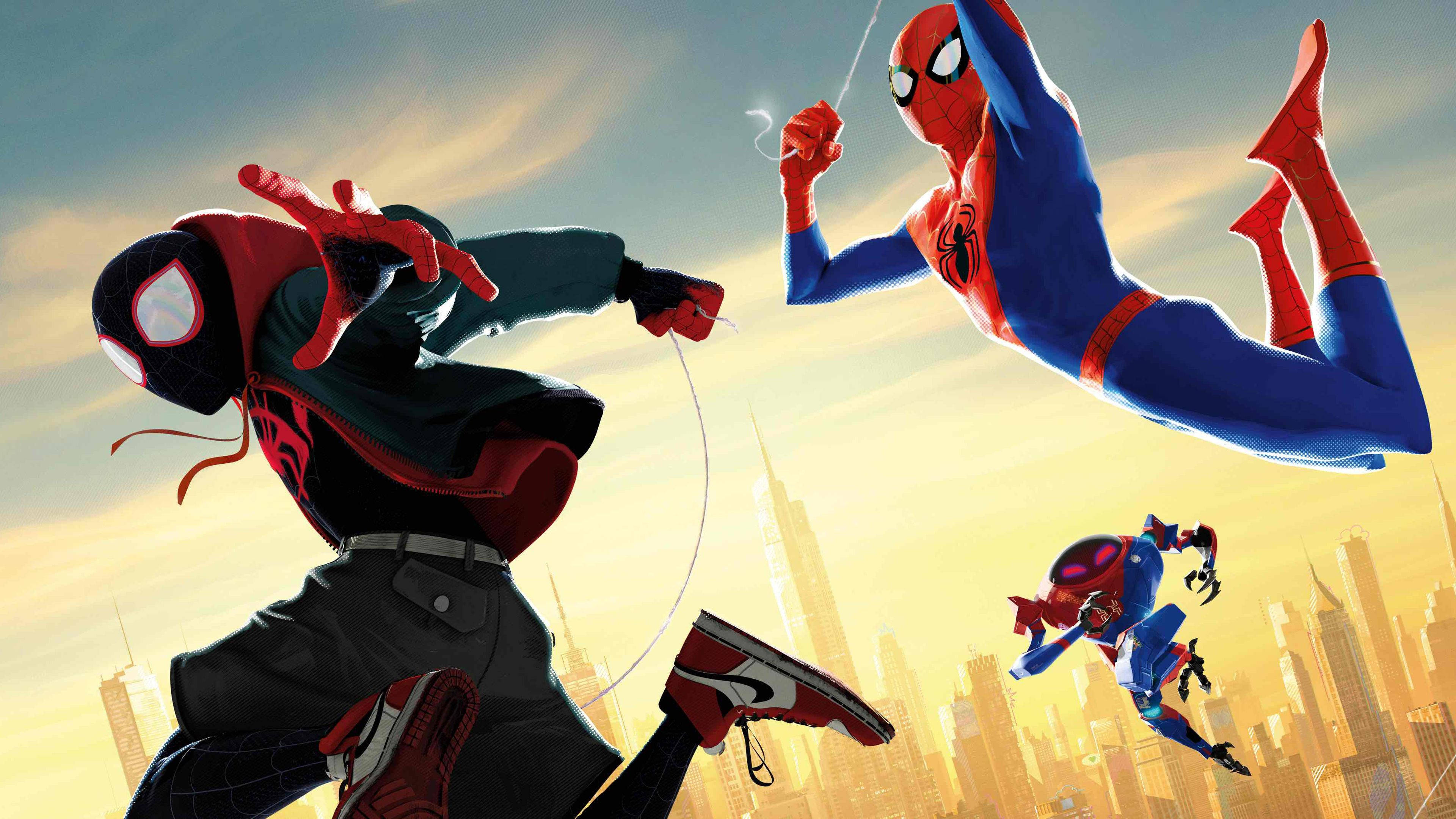 Spider Verse 桌布 壁紙 — 三個蜘蛛人角色在日落時分，在金黃色的城市天際線前動態擺盪。