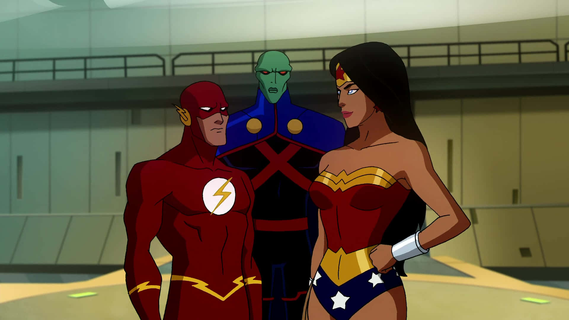 Justice League Crisis On Two Earths 桌布 壁紙 — 三個超級英雄角色自信地站在一個現代室內環境中，周圍有金屬牆壁和欄杆。