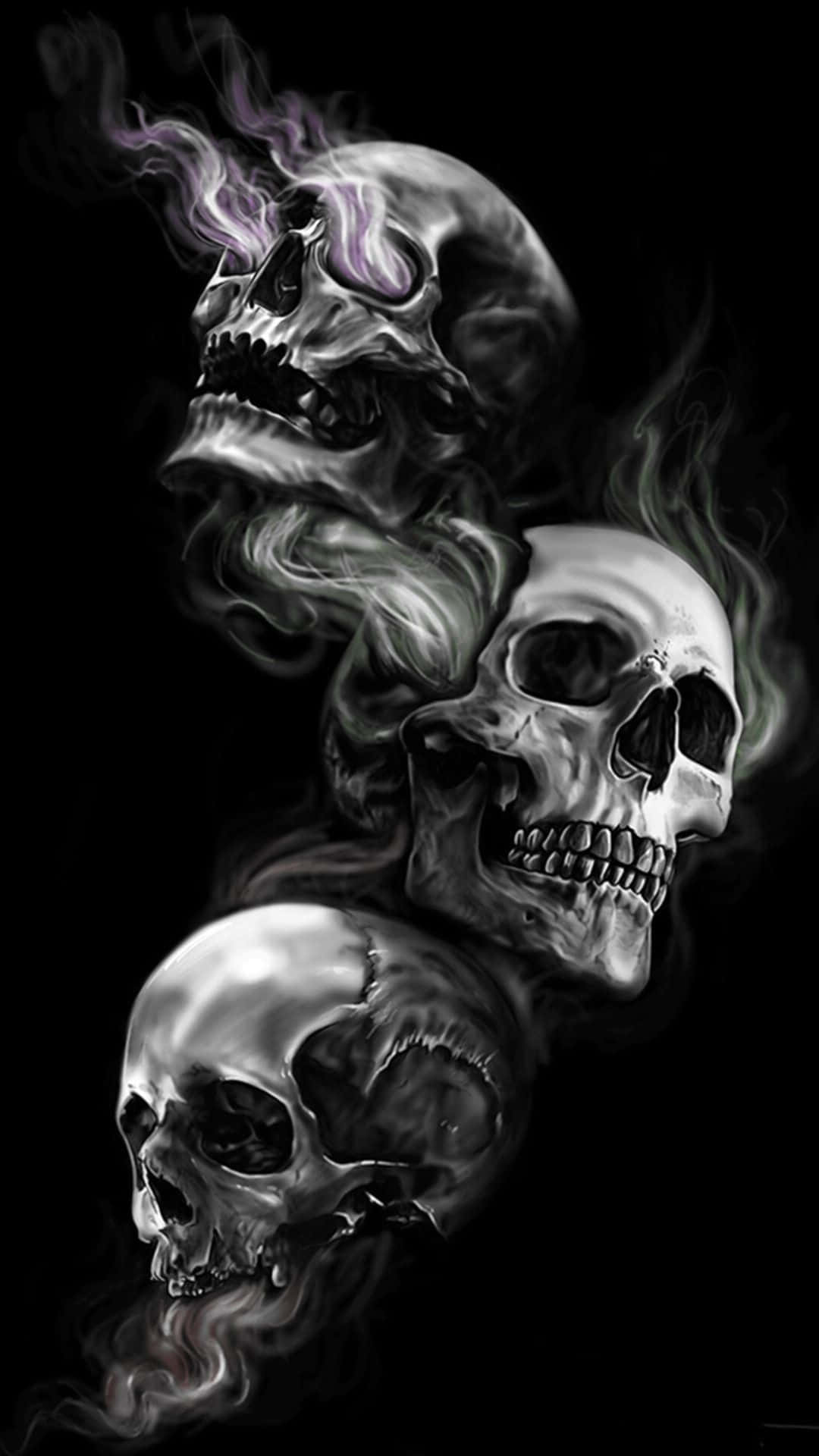 Evil Skull 桌布 壁紙 — 三個金屬骷髏頭垂直漂浮在黑色背景上，頂部骷髏頭冒出旋轉的煙霧和紫色火焰。