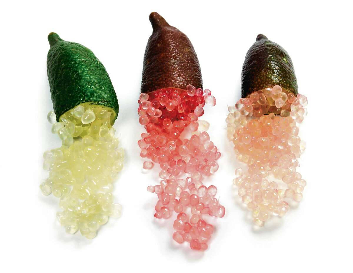 Fruits 桌布 壁紙 — 三個金桔切開，露出閃閃發光的半透明種子，散落在純白背景上。