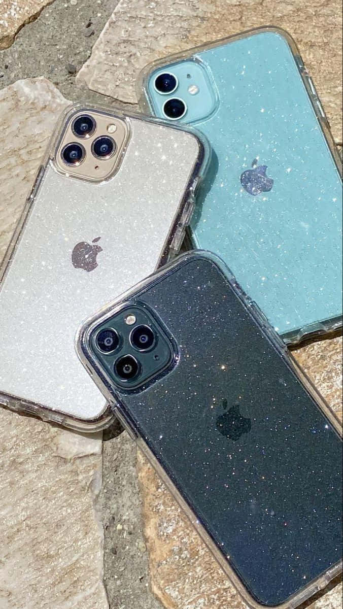 石頭表面上的三個閃粉手機殼 — iPhone 14 壁紙