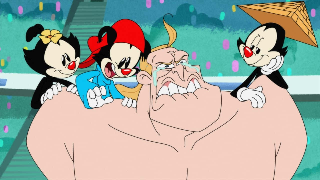 Animaniacs 桌布 壁紙 — 三個頑皮的卡通人物在充滿活力的動畫場景中，開心地折磨一個驚恐的相撲選手。