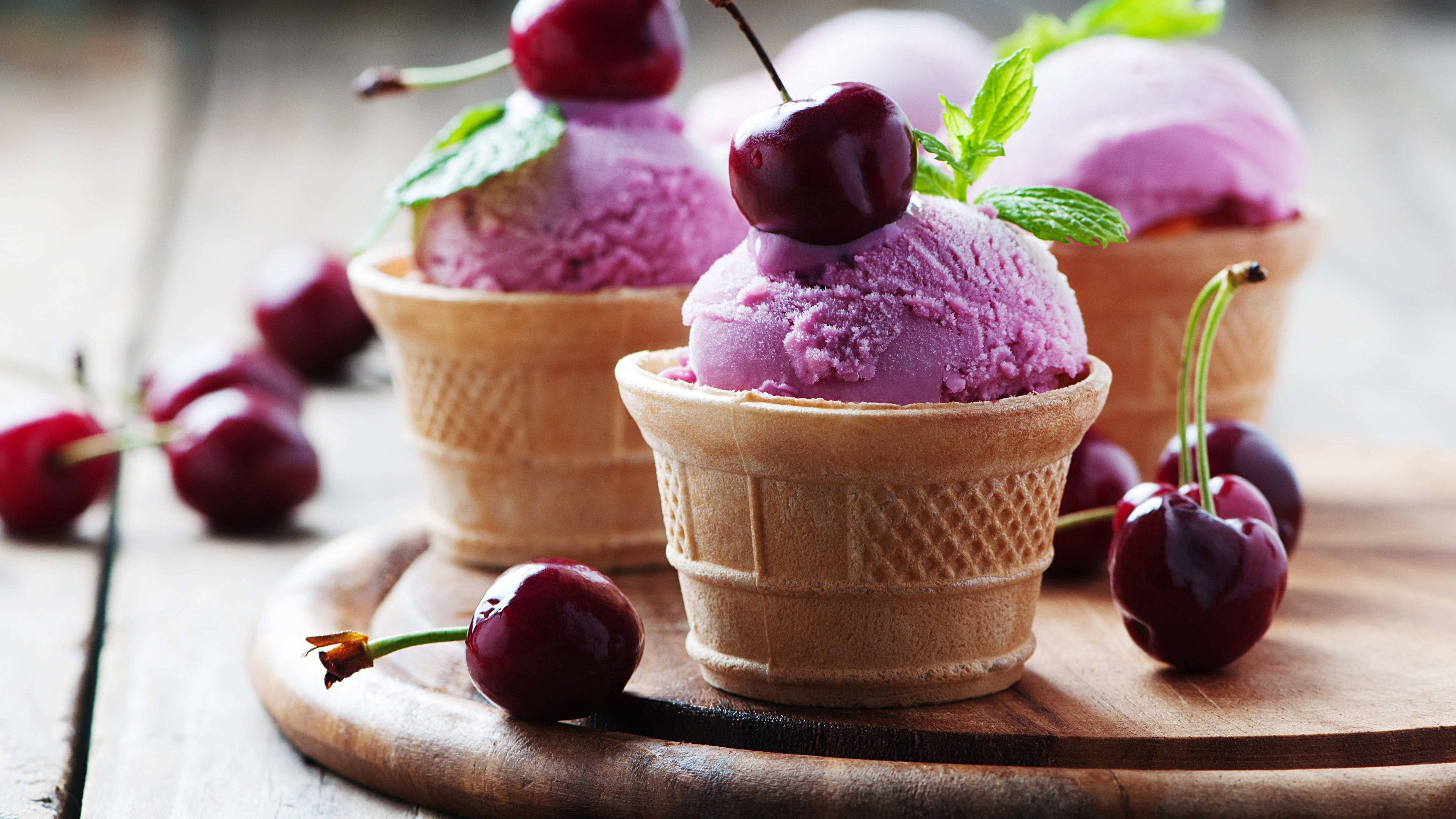 Cherry 桌布 壁紙 — 三個鬆餅筒裝滿充滿活力的紫色櫻桃冰淇淋，上面放上新鮮櫻桃和薄荷葉，放在質樸的木板上。