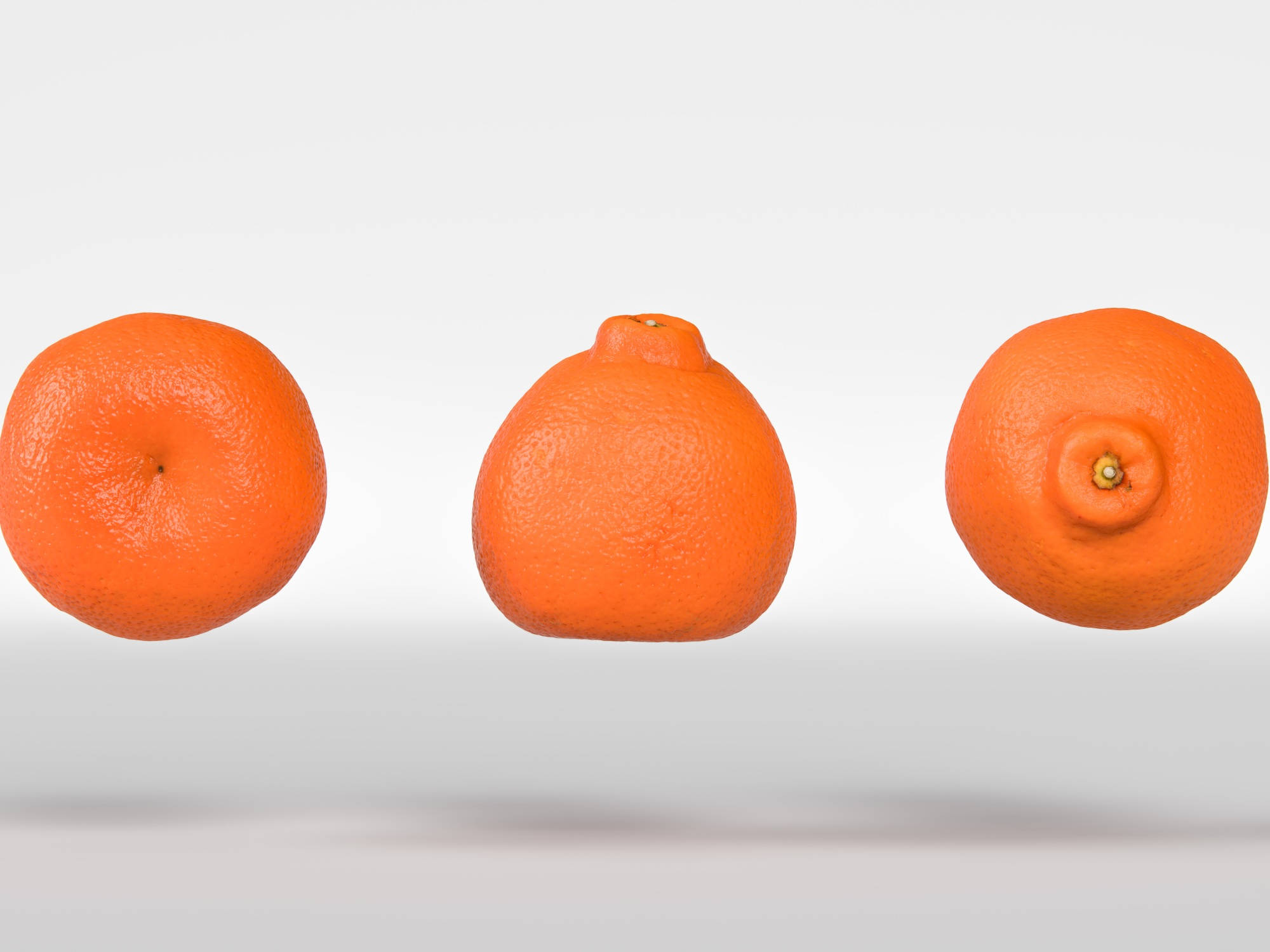 Fruits 桌布 壁紙 — 三個鮮豔的柳橙懸浮在半空中，背景是柔和的漸層色，展現出它們有紋理的果皮和天然的凹痕。