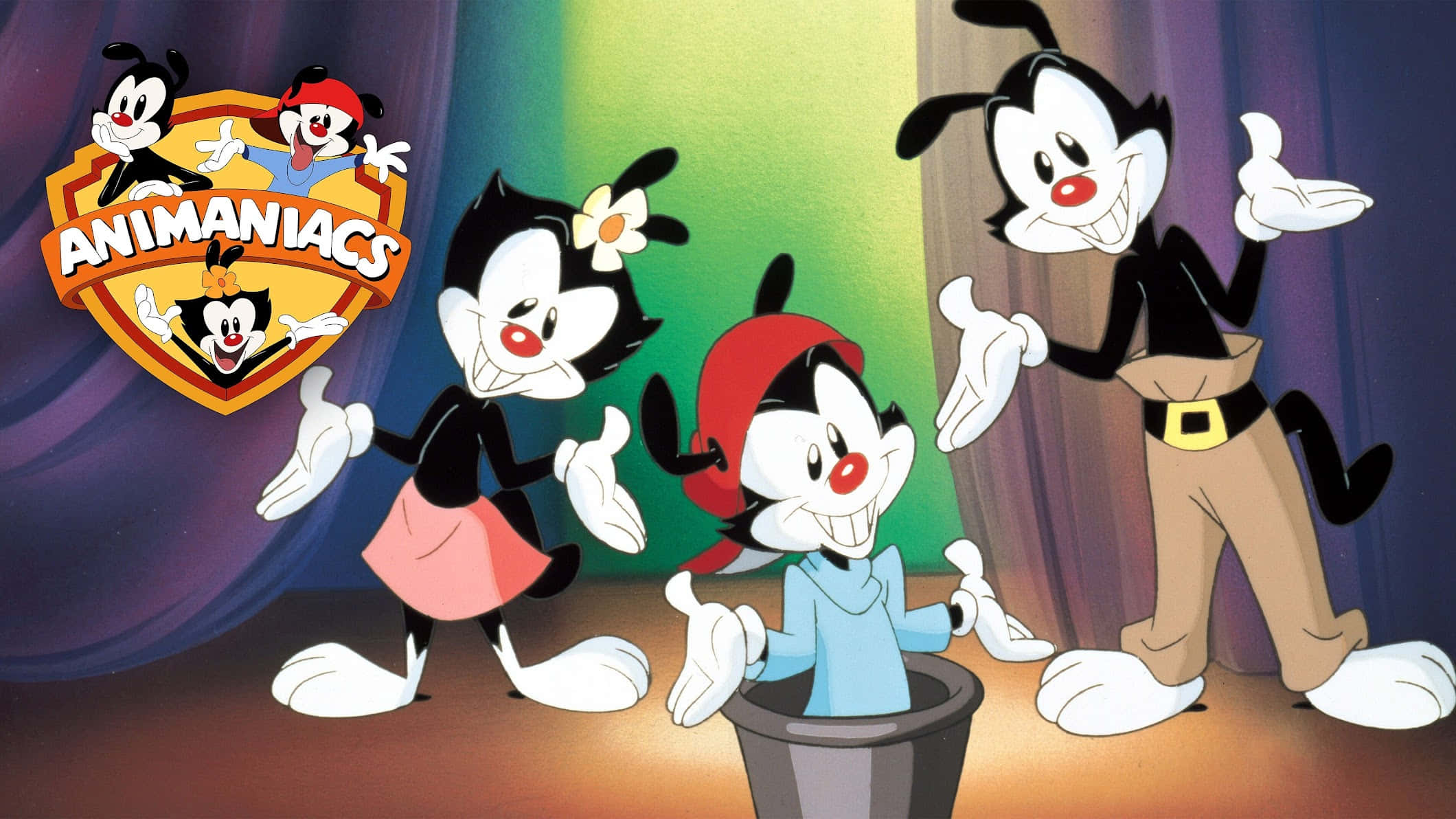 Animaniacs 桌布 壁紙 — 三個黑白動畫搗蛋鬼，紅鼻子，在彩色窗簾下的舞台上開心地擺姿勢。