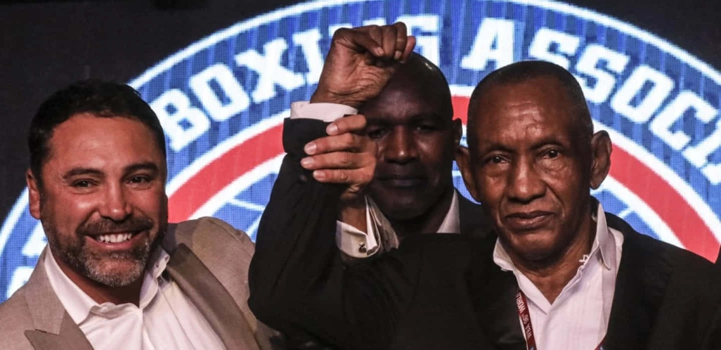 Boxing 桌布 壁紙 — 三名男子在拳擊活動中擺姿勢，其中一人舉起戴著手套的拳頭，背景為「BOXING ASSOCIATION」。