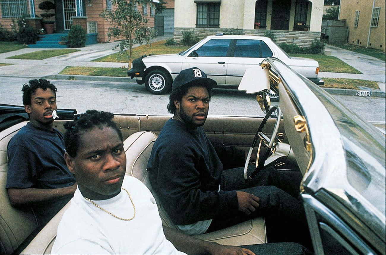 Boyz N The Hood 桌布 壁紙 — 三名男子坐在一輛復古敞篷車上，位於郊區街道，附近停著一輛銀色轎車。