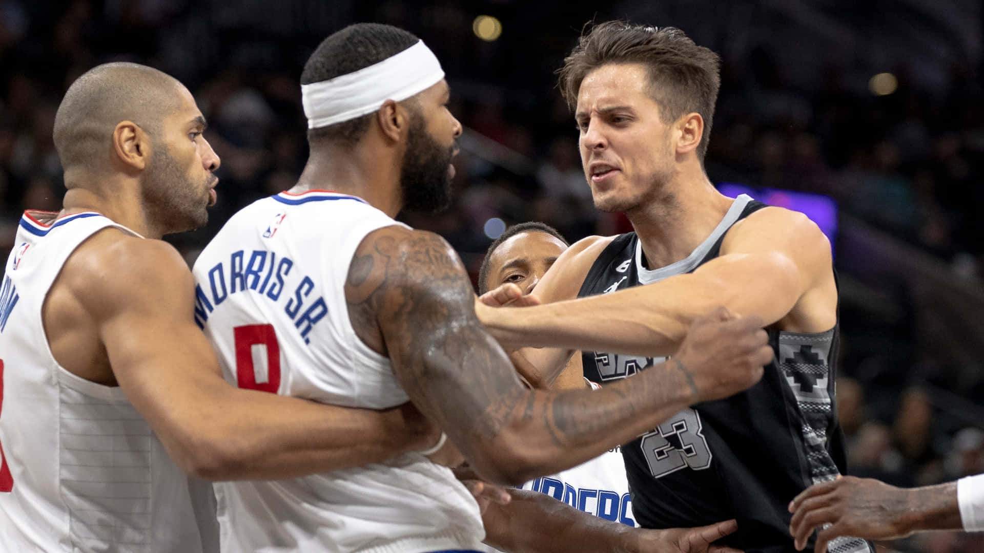 NBA 桌布 壁紙 — 三名籃球運動員在場館燈光下於比賽激烈時刻激烈對峙。