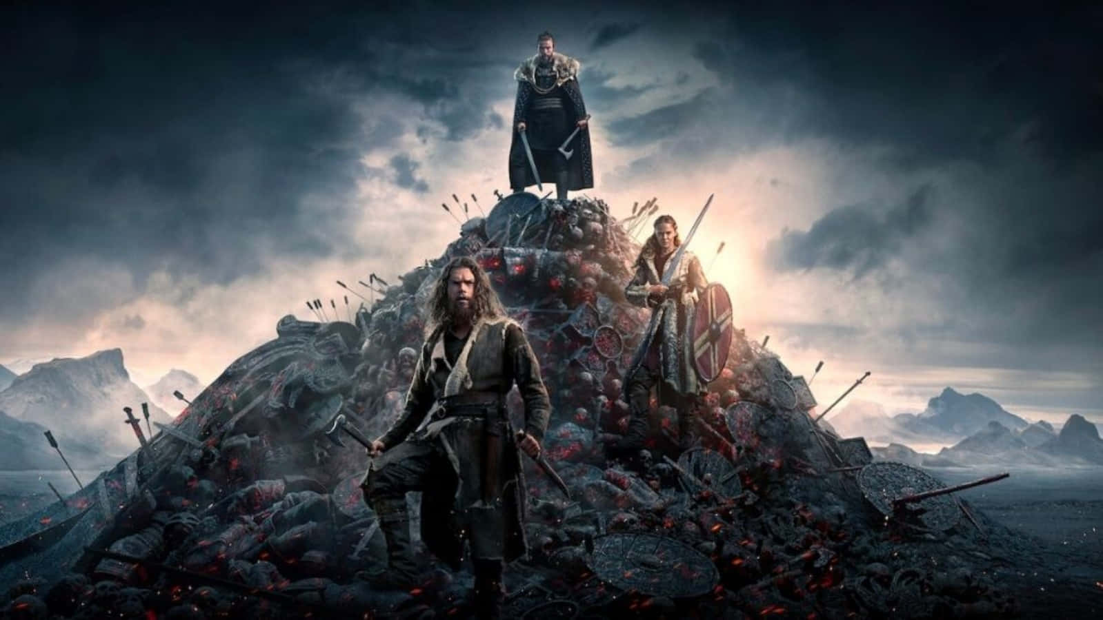 Vikings 桌布 壁紙 — 三名維京戰士站在血染的戰場土丘上，天空風暴來襲，遠山隱現。
