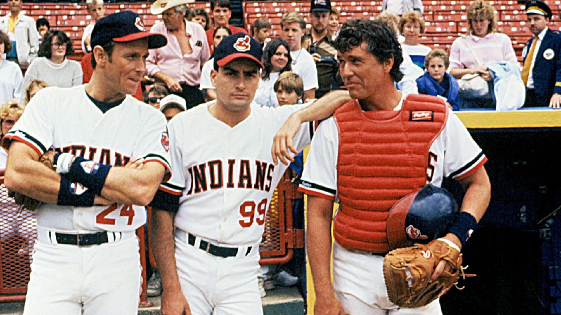 Major League Movie 桌布 壁紙 — 三名身穿印第安人隊球衣的棒球選手一起站在體育場的球員休息區，背景有球迷。