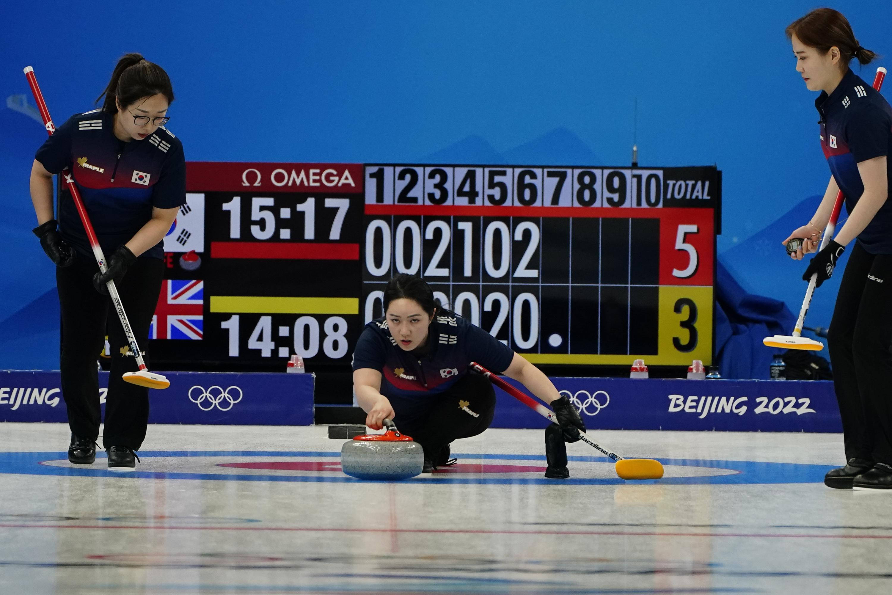 Olympics 桌布 壁紙 — 三名身穿深色制服的韓國冰壺運動員在北京2022冬奧冰壺比賽中，在拋光的冰場上專注比賽。