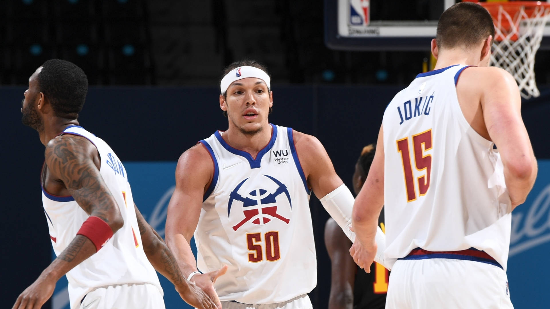 aaron gordon 桌布 壁紙 — 三名身穿白色丹佛金塊球衣的籃球運動員在明亮的場館燈光下於球場上圍攏。