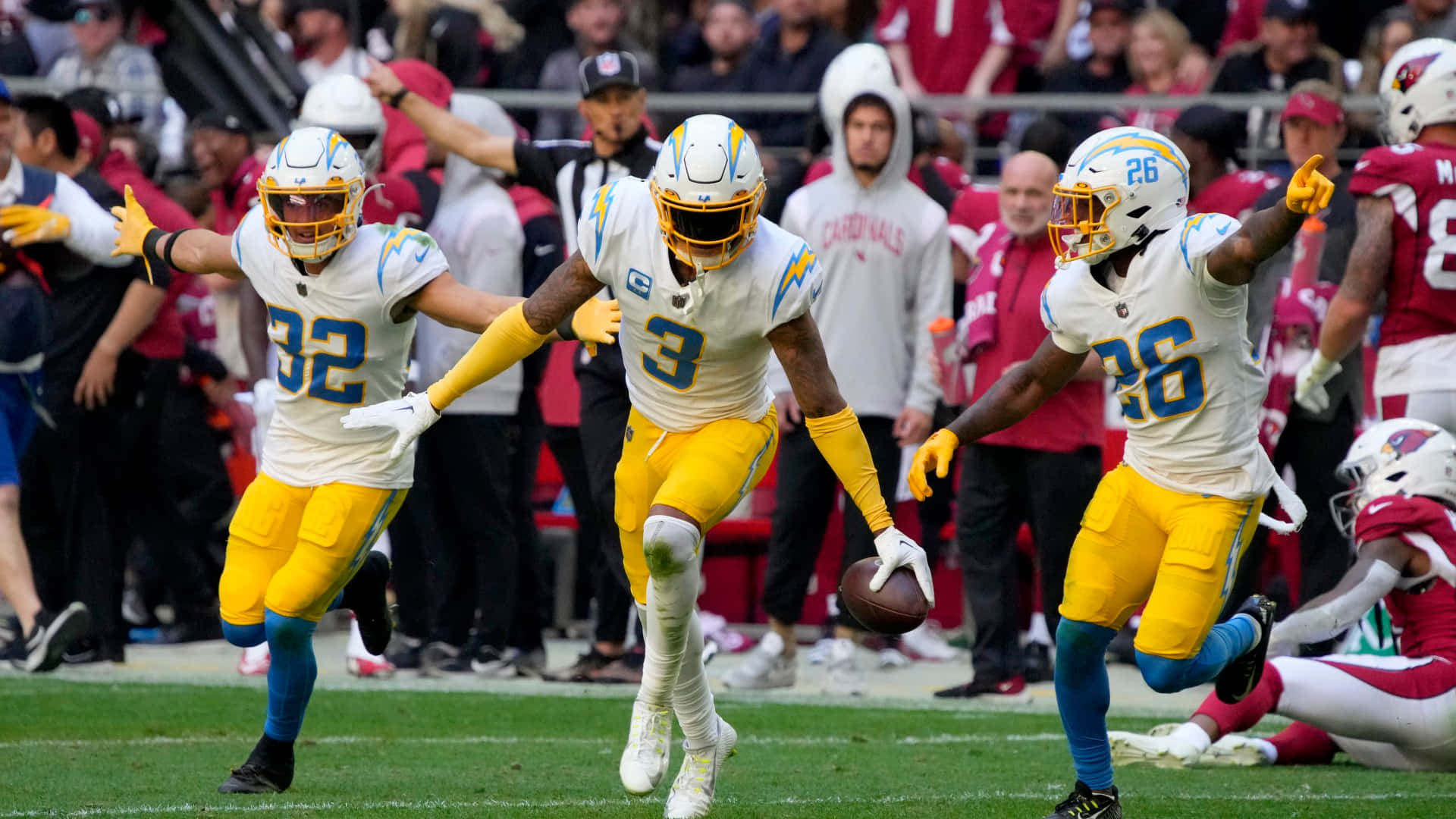 NFL 桌布 壁紙 — 三名身穿白色和黃色球衣的 Chargers 美式足球員在綠色球場上慶祝達陣，背景有球迷。