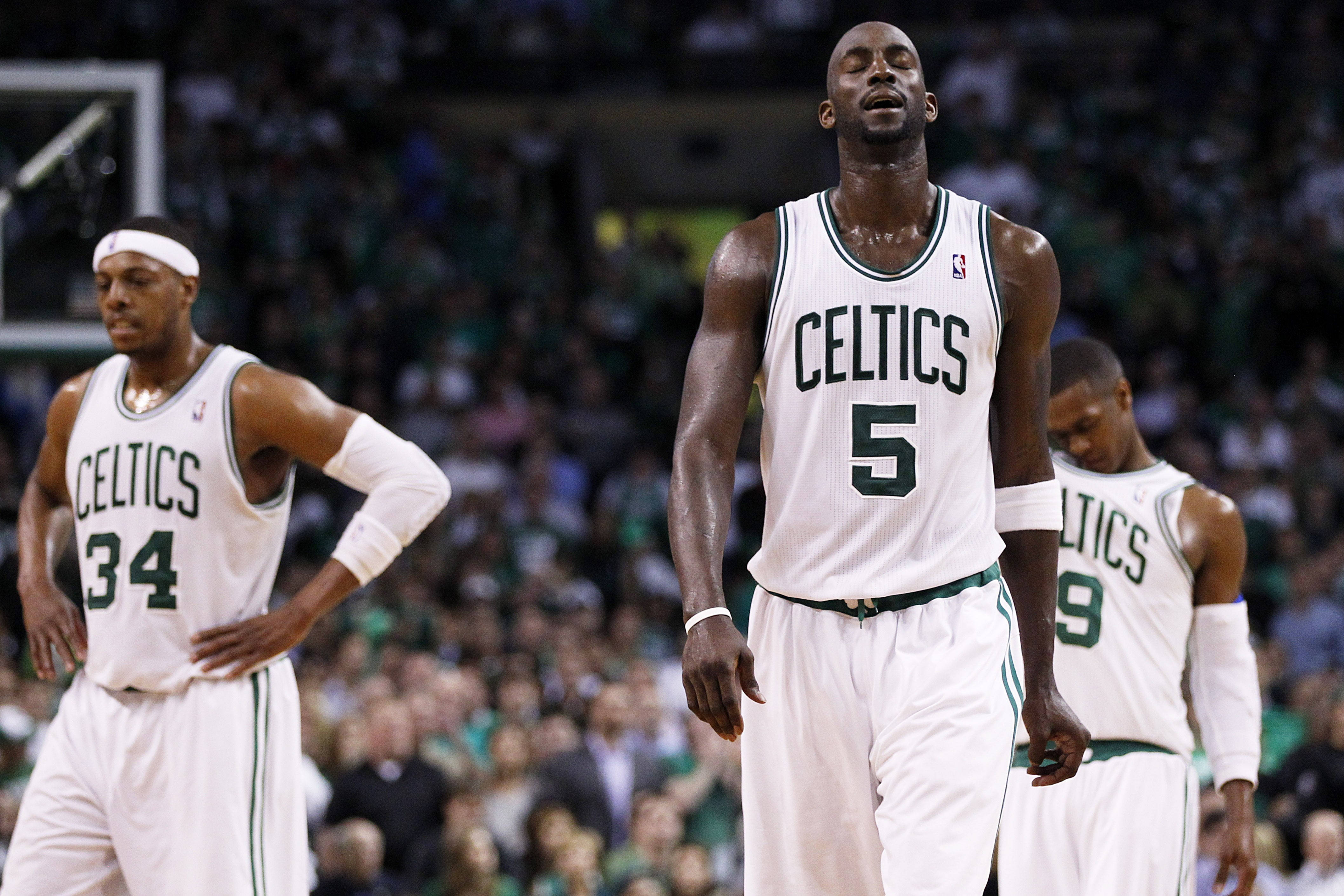 Paul Pierce 桌布 壁紙 — 三名身穿白色球衣的波士頓塞爾提克籃球運動員在球場上沮喪地站著，身後是模糊的人群。