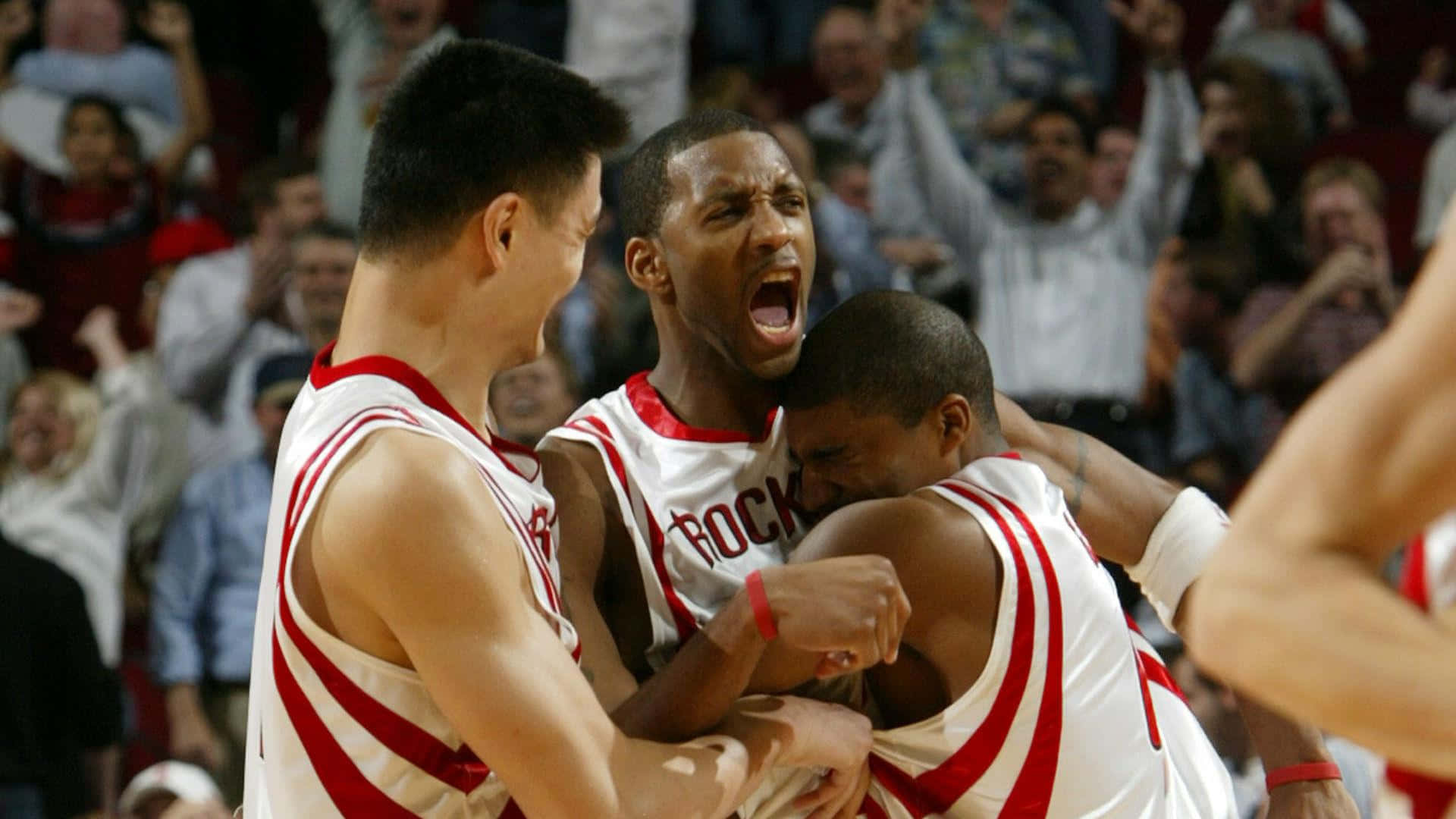 Tracy Mcgrady 桌布 壁紙 — 三名身穿紅白球衣的籃球運動員在球場上激烈慶祝，身後有歡呼的人群。
