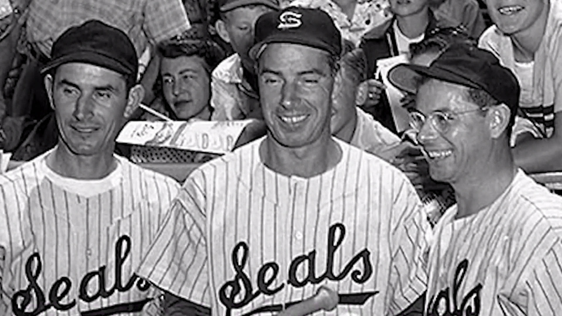 Joe Dimaggio 桌布 壁紙 — 三名身穿細條紋海豹隊制服、面帶微笑的棒球運動員在球迷的背景下合影留念。