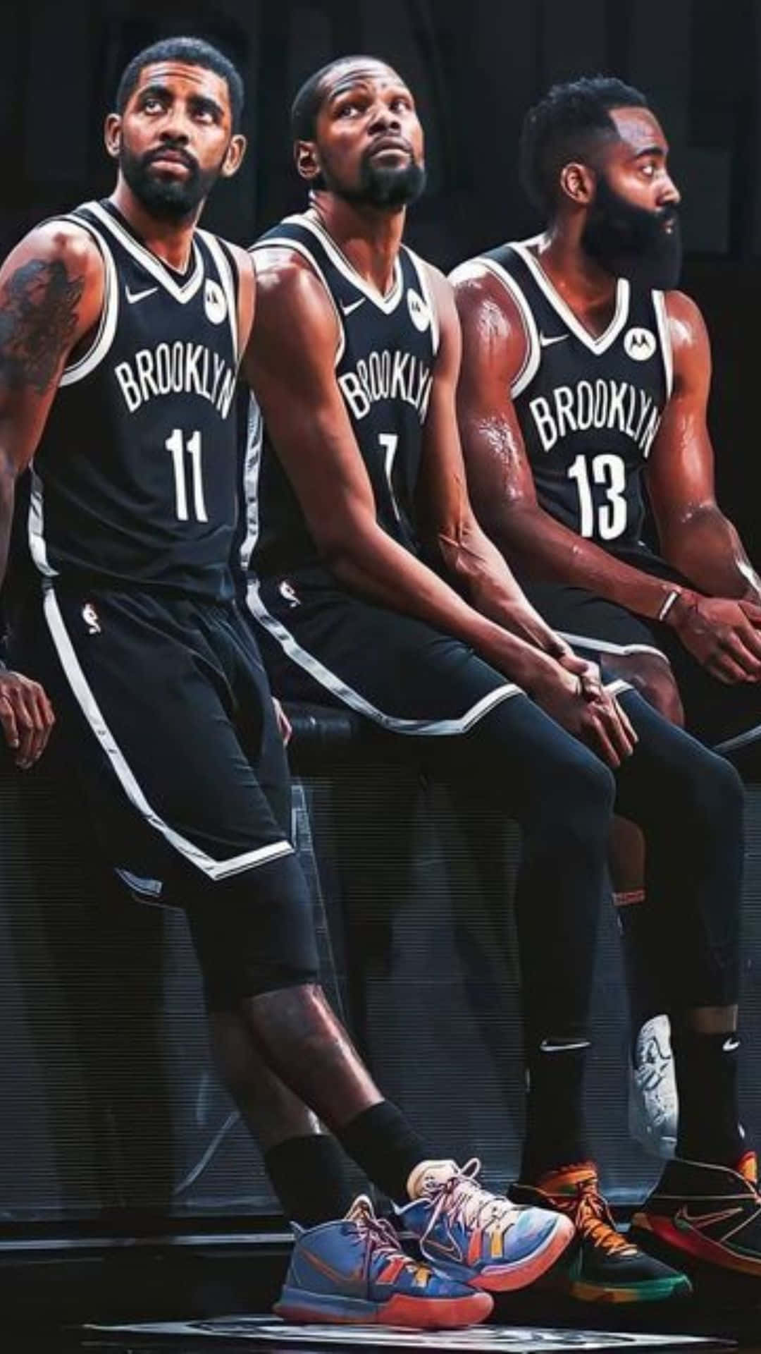 Brooklyn Nets 桌布 壁紙 — 三名身穿黑色球衣的布魯克林籃網隊籃球運動員並排坐在長凳上，神情專注。