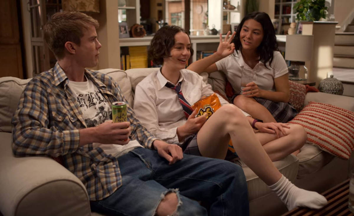 Netflix 桌布 壁紙 — 三名青少年在溫暖照明的客廳沙發上放鬆，分享零食和交談。