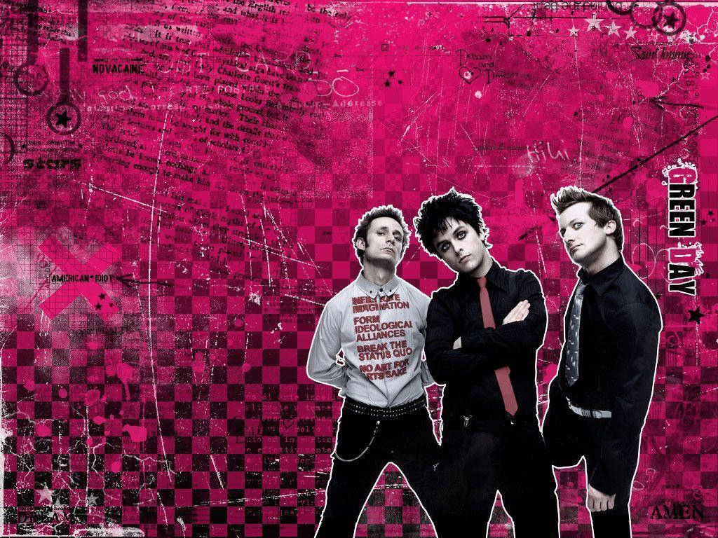 Green Day 桌布 壁紙 — 三名龐克搖滾歌手挑釁地站在充滿活力的粉紅和黑色格子塗鴉牆前。