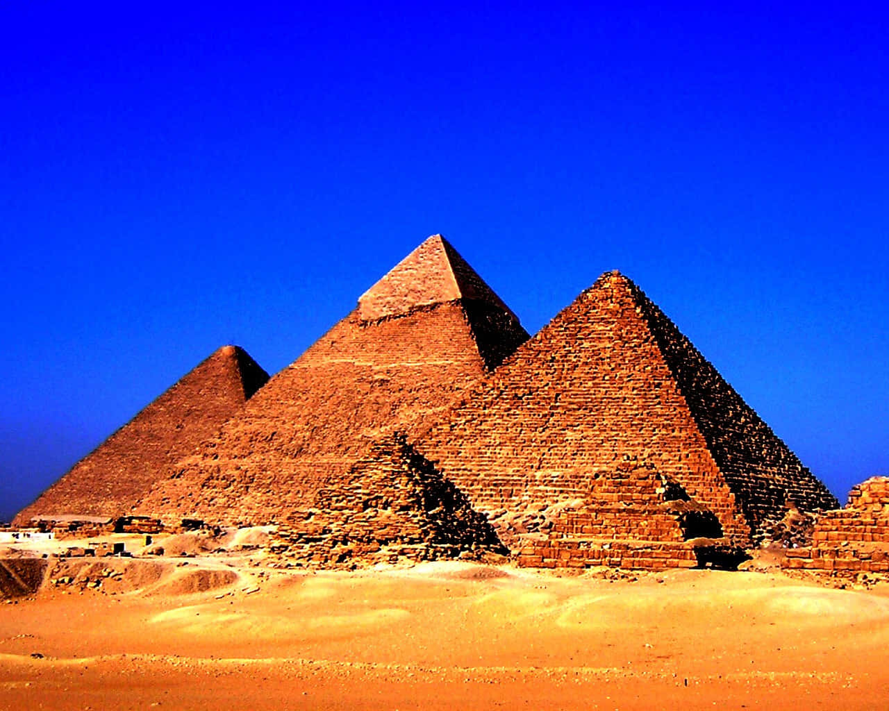 Egypt Pyramids 桌布 壁紙 — 三座古老金字塔在燦爛藍天下從金色沙漠中雄偉地升起。