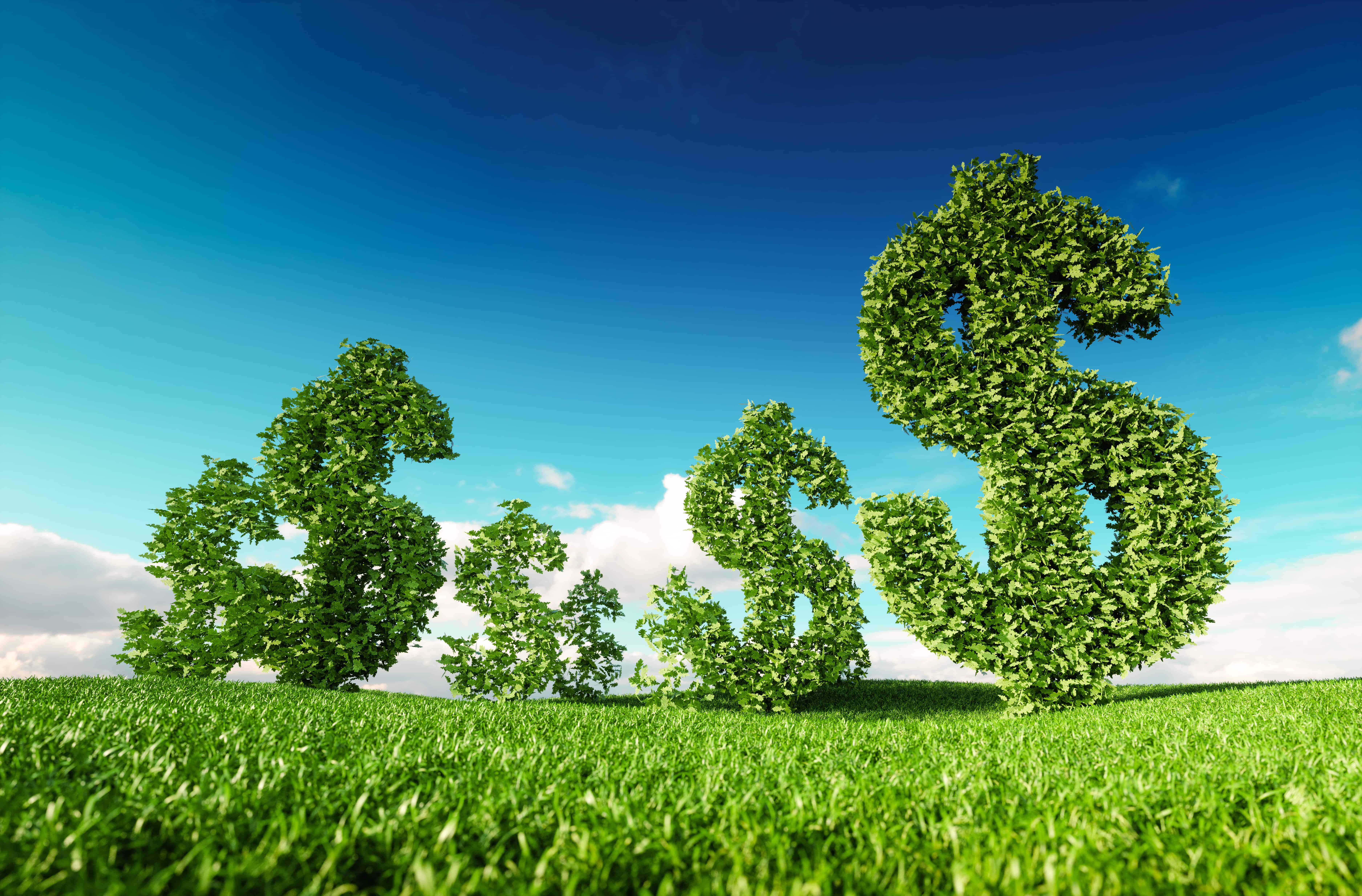 Green Economy 桌布 壁紙 — 三座茂盛的綠色美元符號雕塑從充滿活力的草地上聳立，背景是清澈的藍天和蓬鬆的白雲。