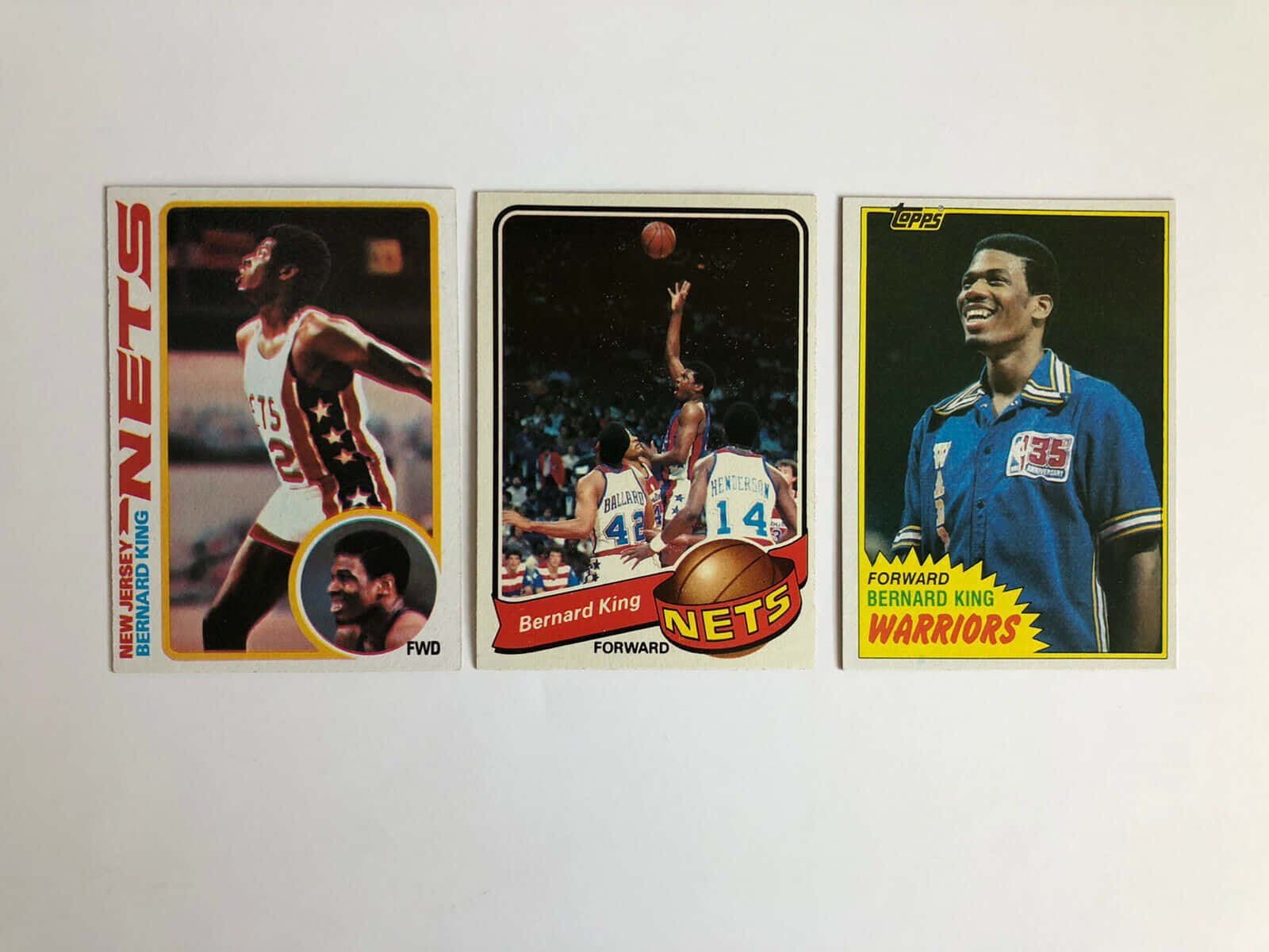 Cards 桌布 壁紙 — 三張伯納德·金的復古籃球交易卡並排展示在純白色表面上。