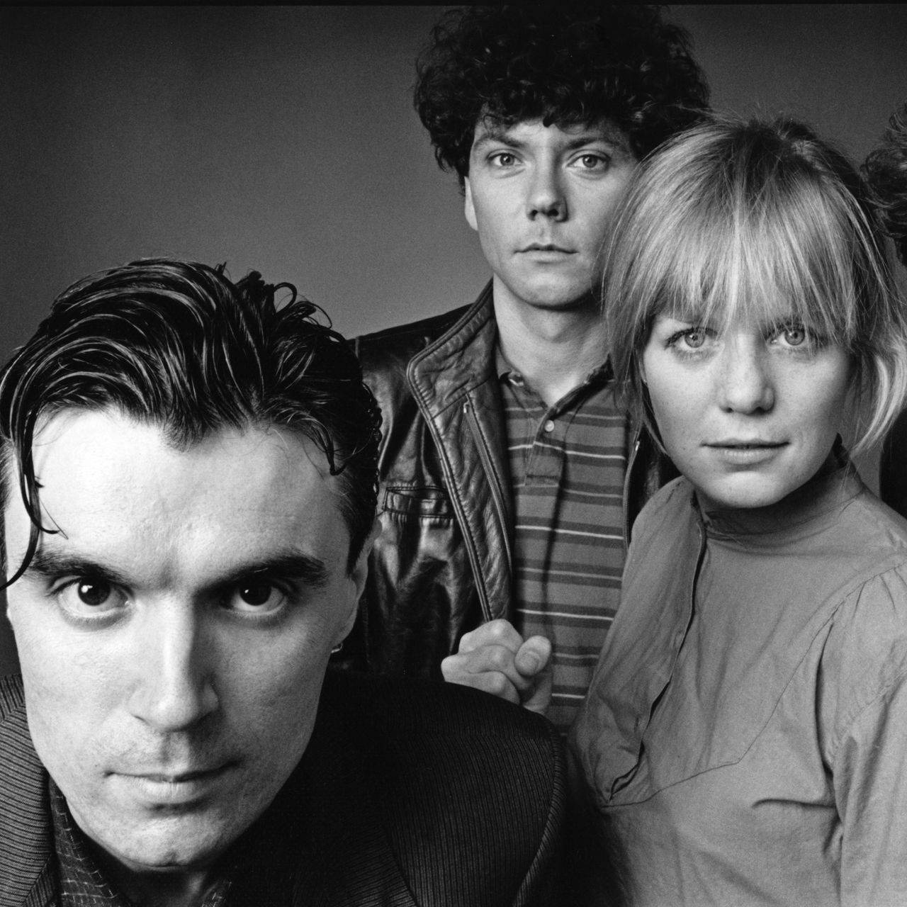 talking heads 桌布 壁紙 — 三張強烈的面孔在黑白鮮明的工作室肖像中向前凝視，帶有戲劇性的燈光。