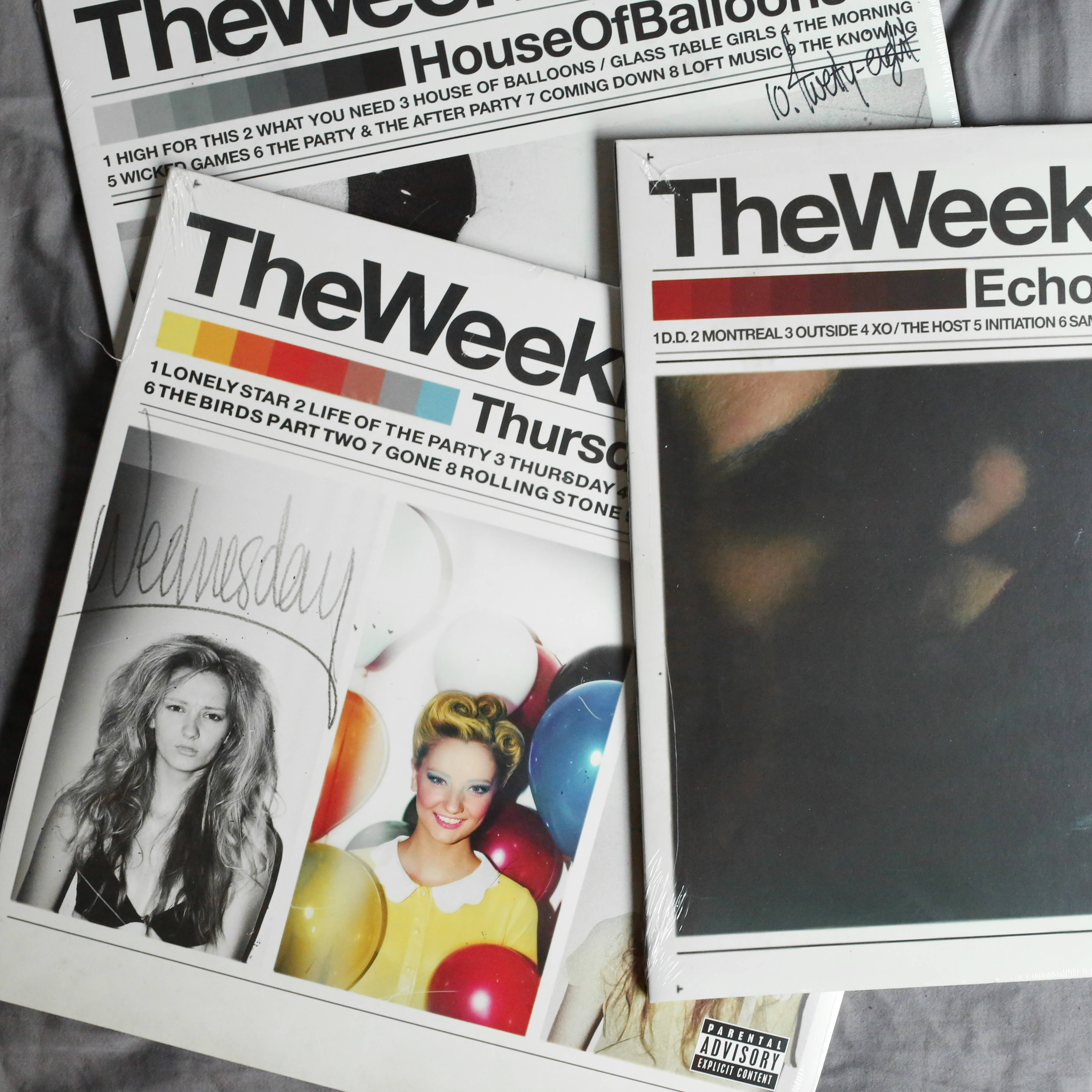 威肯 桌布 壁紙 — 三張復古The Week雜誌封面，帶有粗體字體和普普藝術圖像，放在有紋理的灰色布料表面上。