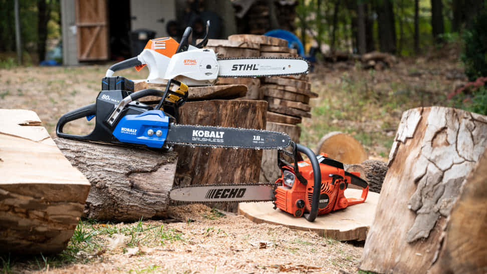 工具 桌布 壁紙 — 三把來自STIHL、Kobalt和Echo品牌的鏈鋸，放置在樹林戶外工作環境中剛砍伐的木頭上。